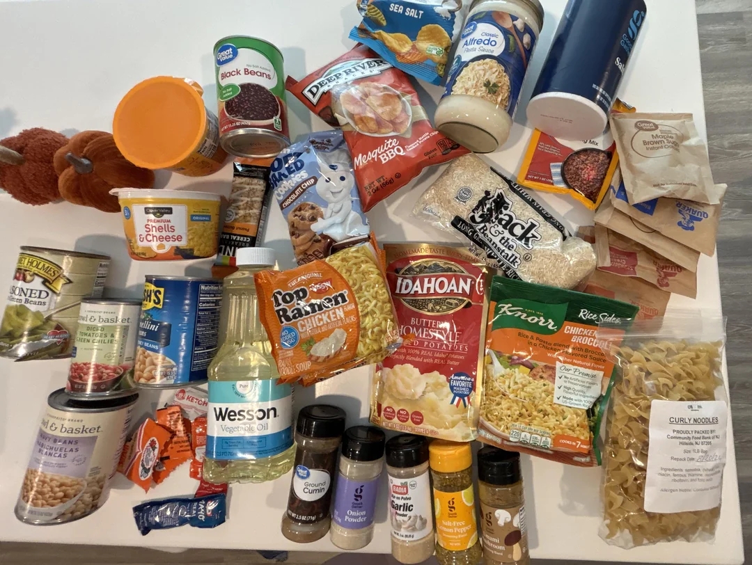Various packaged food items including canned goods, pasta, sauces, and spices arranged on a table