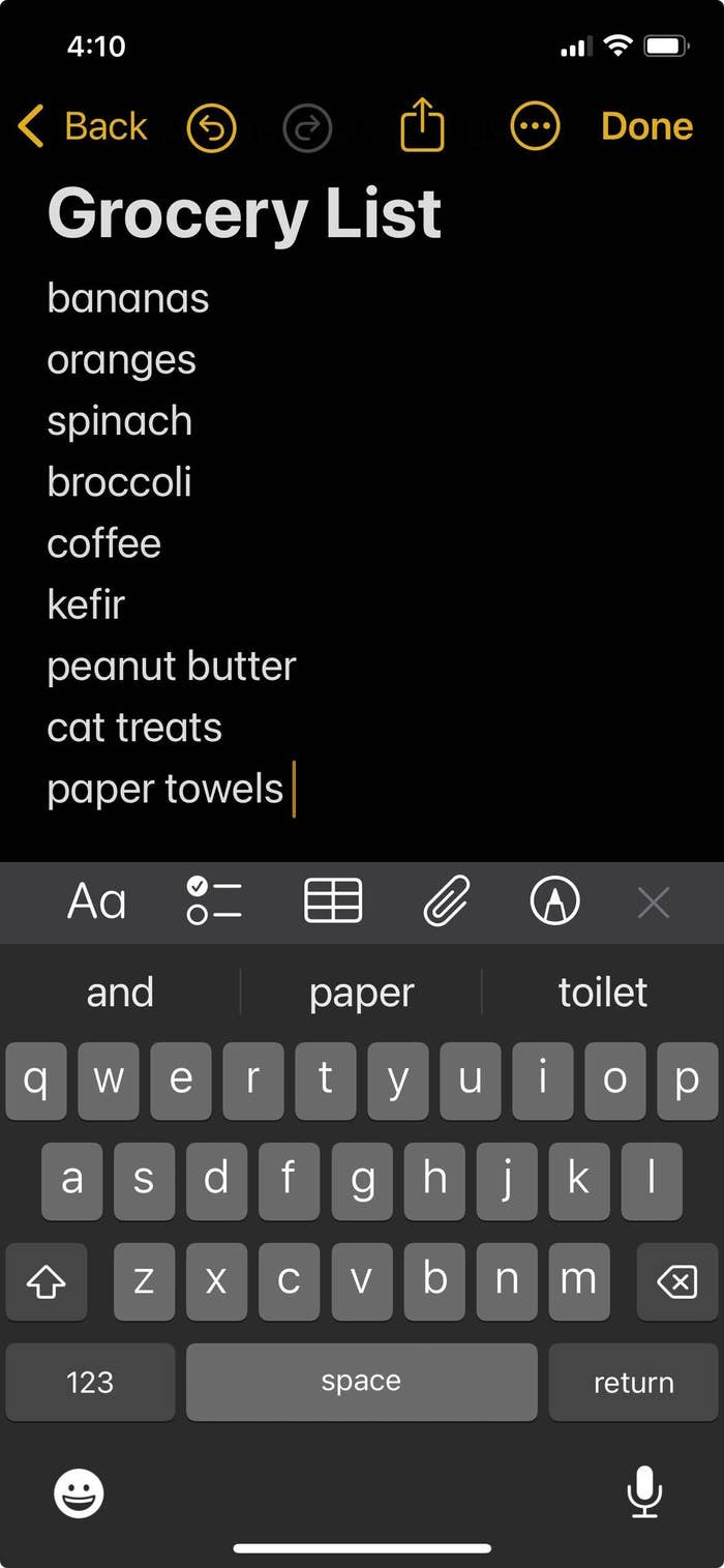 Grocery list on a phone screen: bananas, oranges, spinach, broccoli, coffee, kefir, peanut butter, cat treats, paper towels