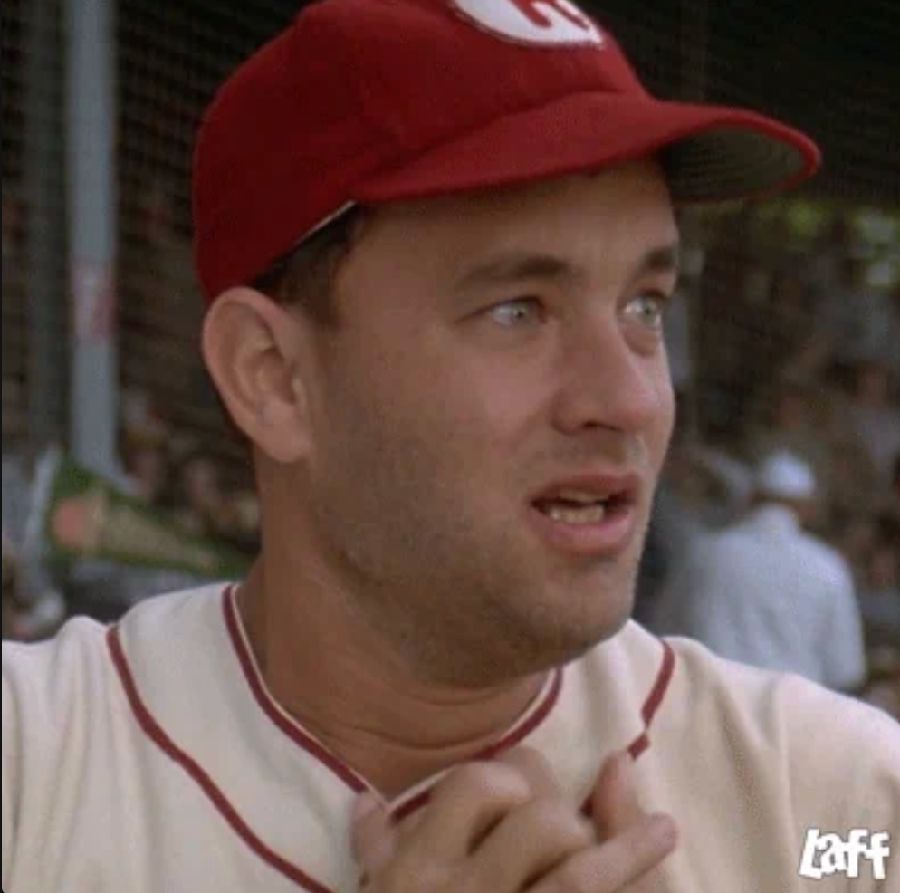 A person in a vintage-style baseball uniform and cap stands on a field, appearing emotional
