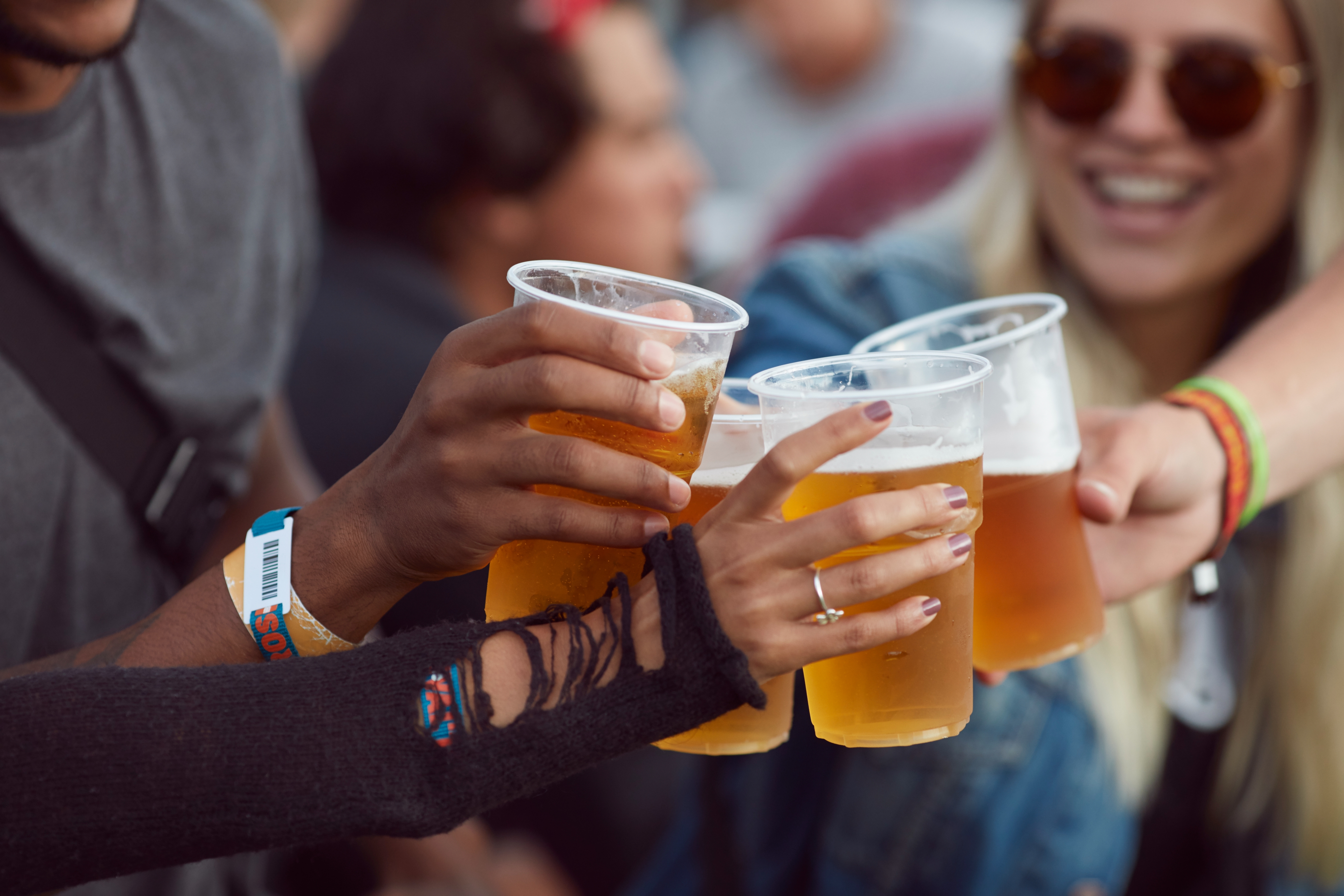 People toasting with plastic cups of beer, suggesting a casual, social gathering