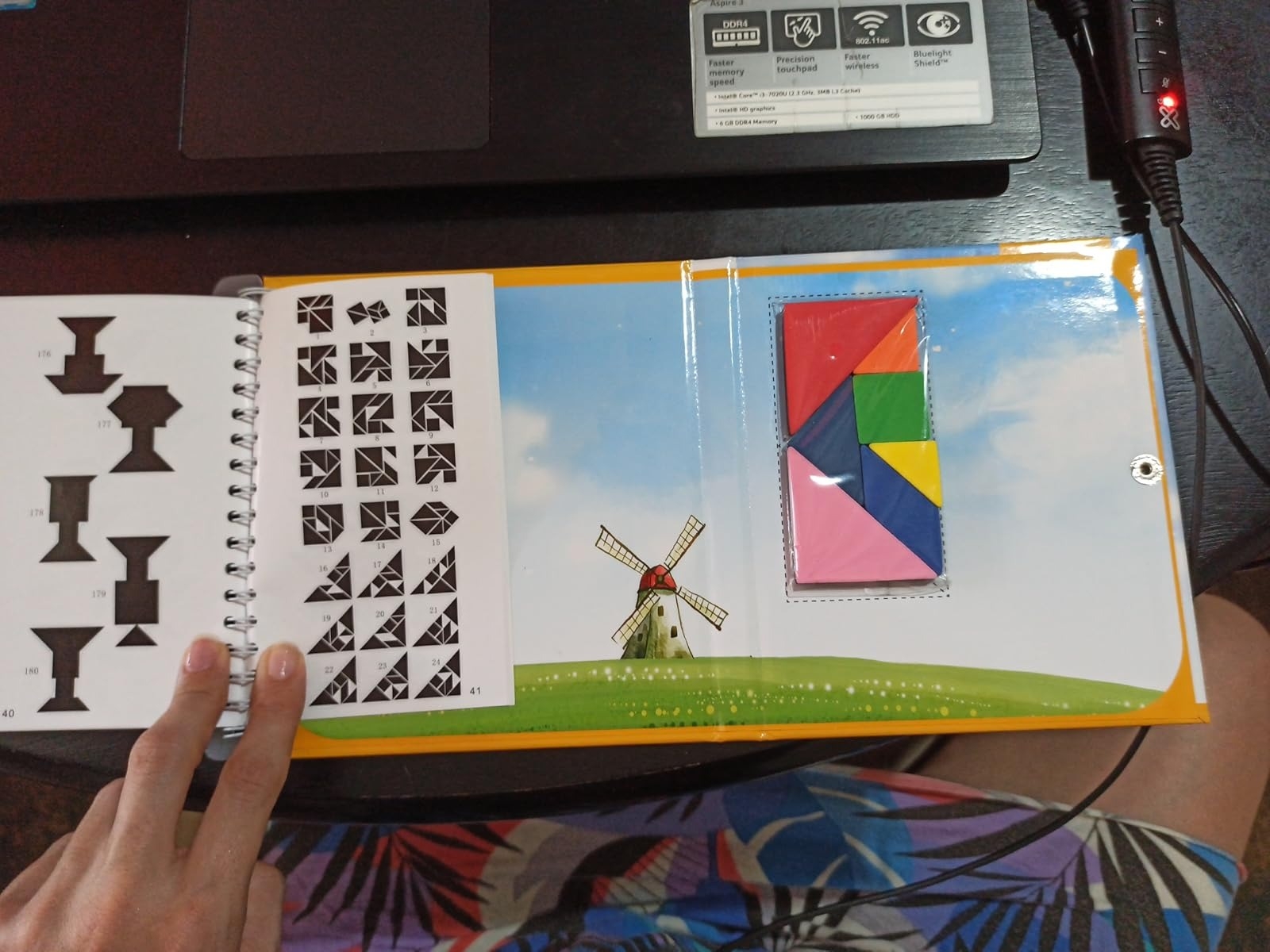 Book with silhouettes for shape matching, tangram set on the side, windmill illustration on the page
