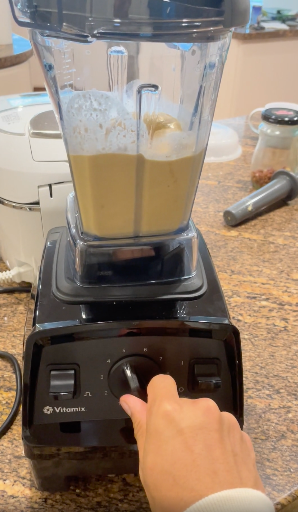 Person using a high-speed blender on a kitchen counter