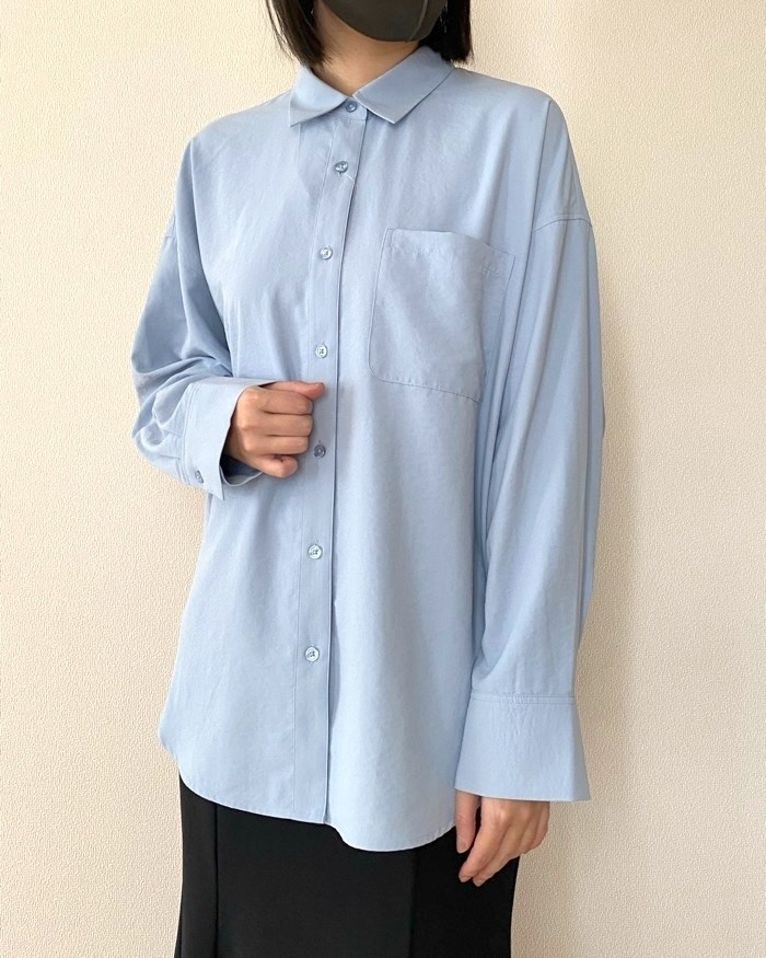 女性がシンプルなシャツとスカートを着用しています。