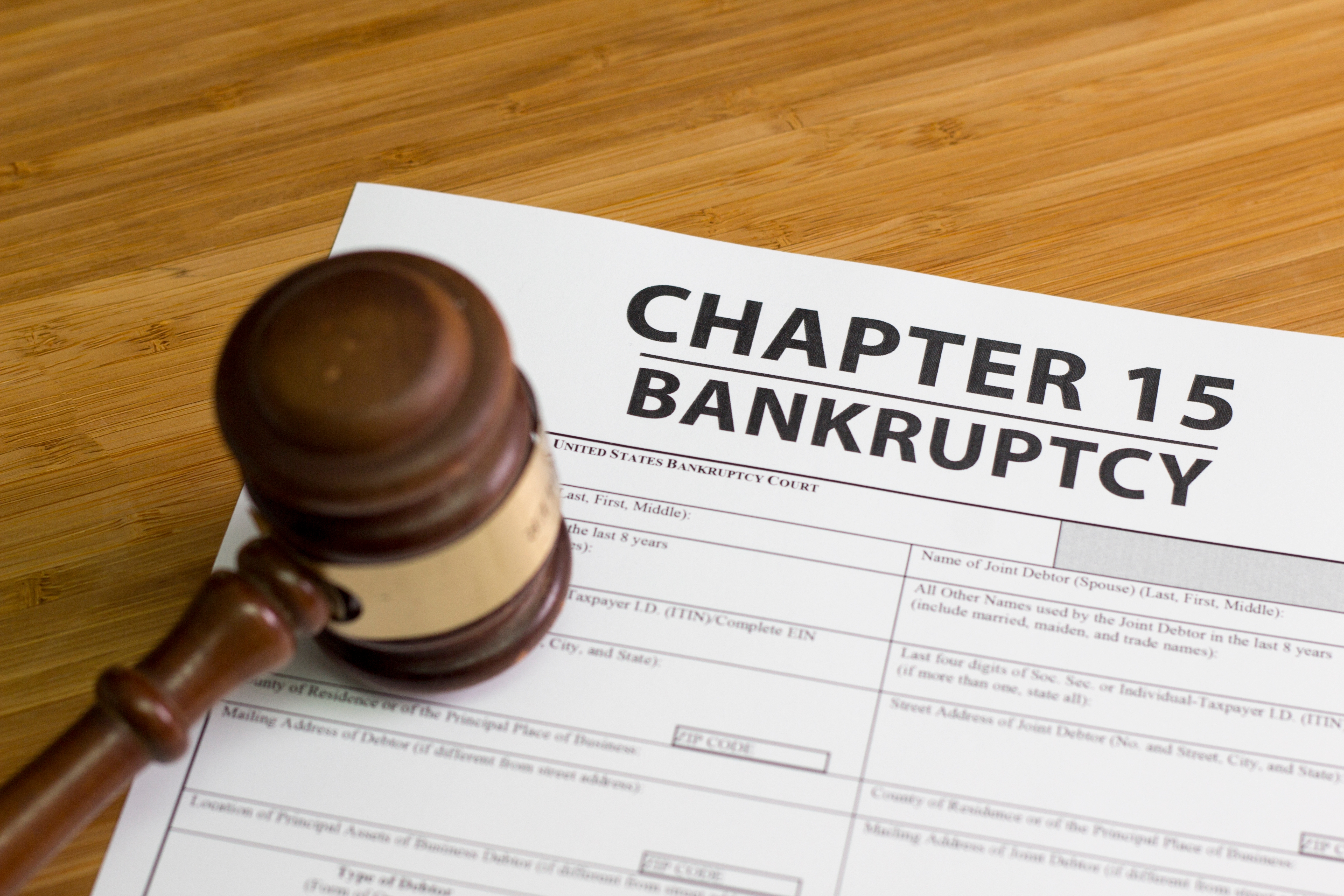 Chapter 15 Bankruptcy form on wooden table with a judge's gavel beside it