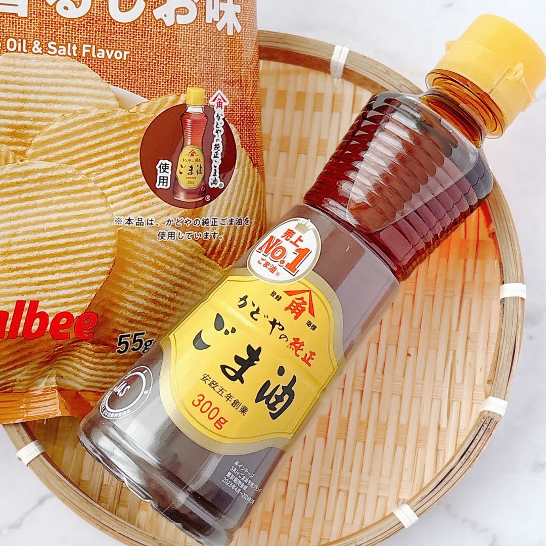 籠にごま油のボトルとポテトチップスの袋が置かれている。商品のラベルが見える。