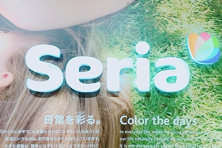 手芸用品店Seriaの広告画像。草の上で寛ぐ人と、英語と日本語のコピーが書かれています。