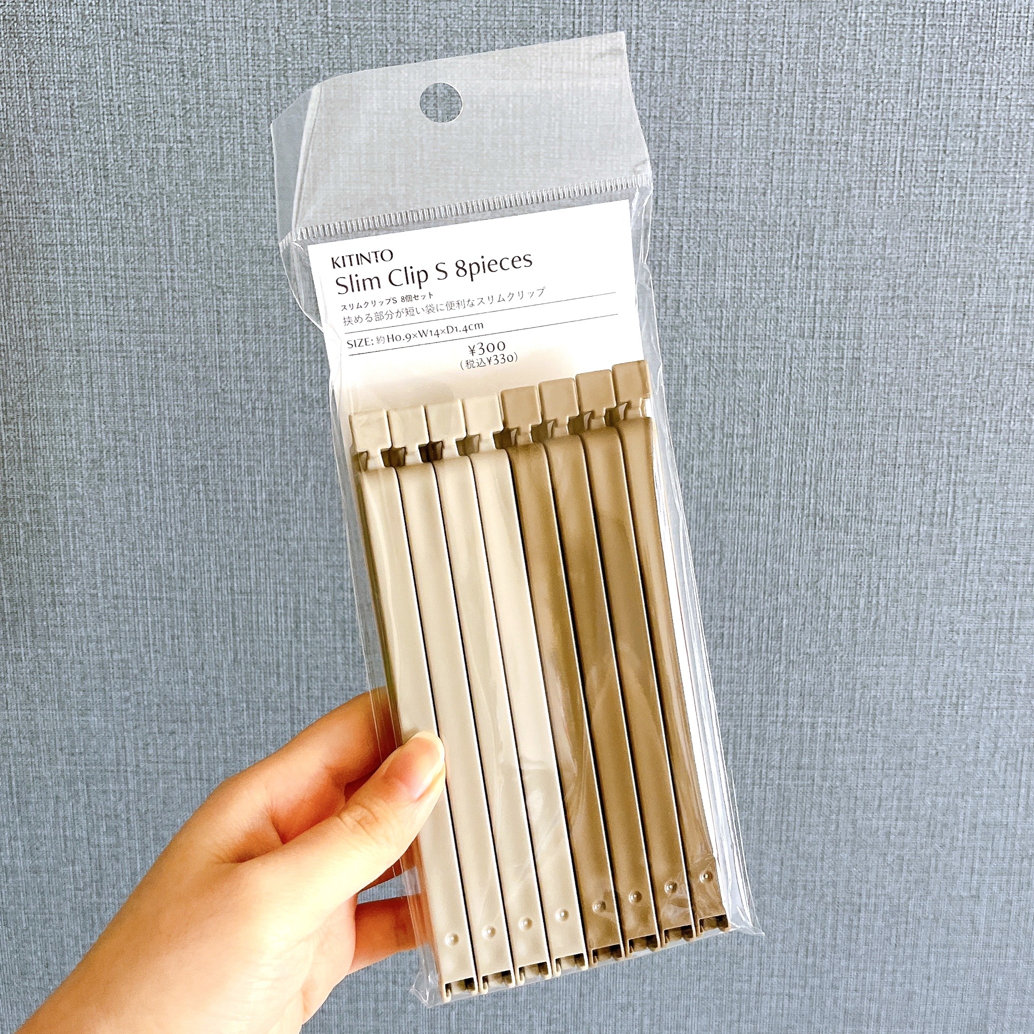 袋に入った8本のスリムクリップを手に持っている様子。クリップは収納や整理に利用可能。