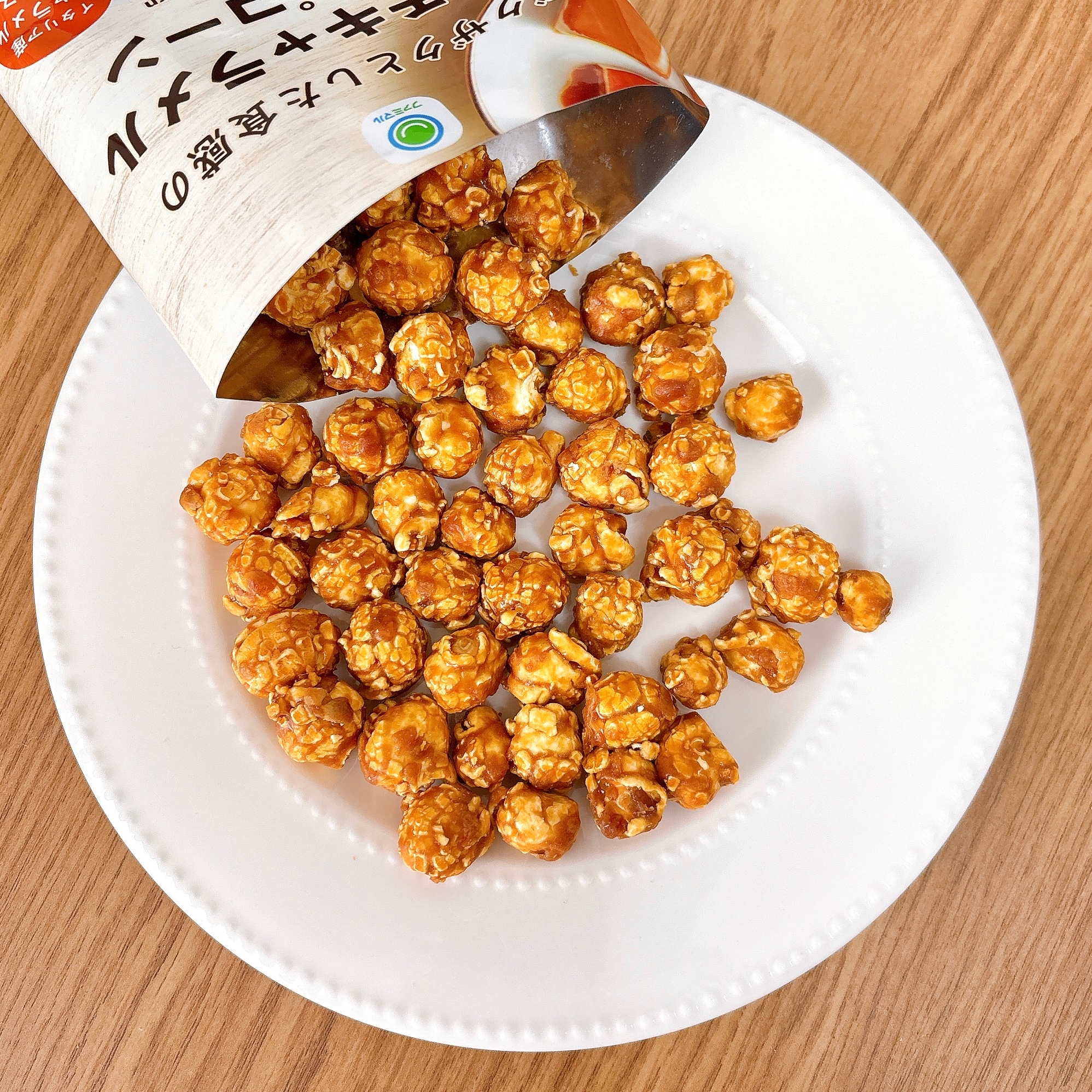 白い皿にキャラメルコーンが載せられている。袋からこぼれている様子。