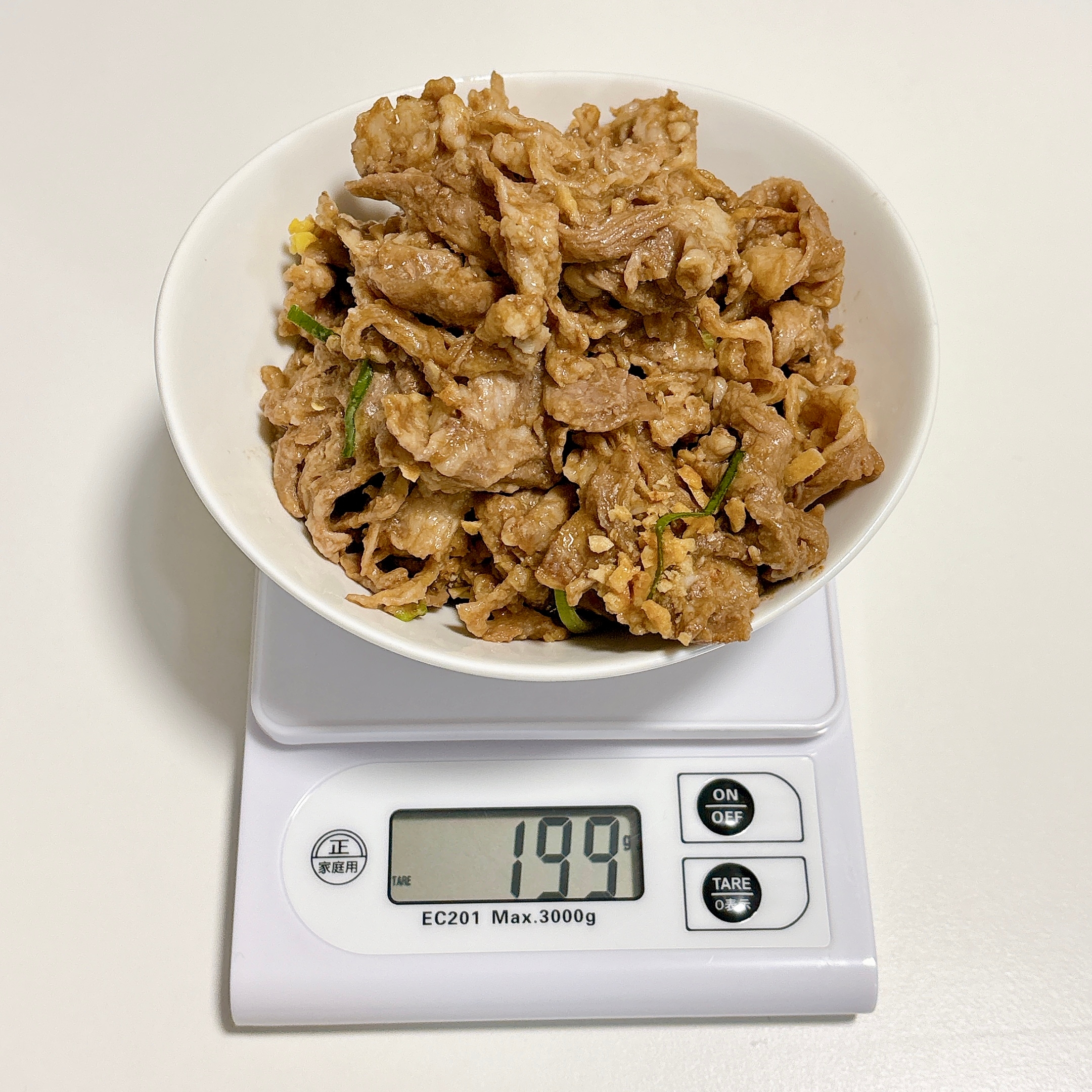 デジタルスケールの上に載ったボウルいっぱいの料理（重量199g）。