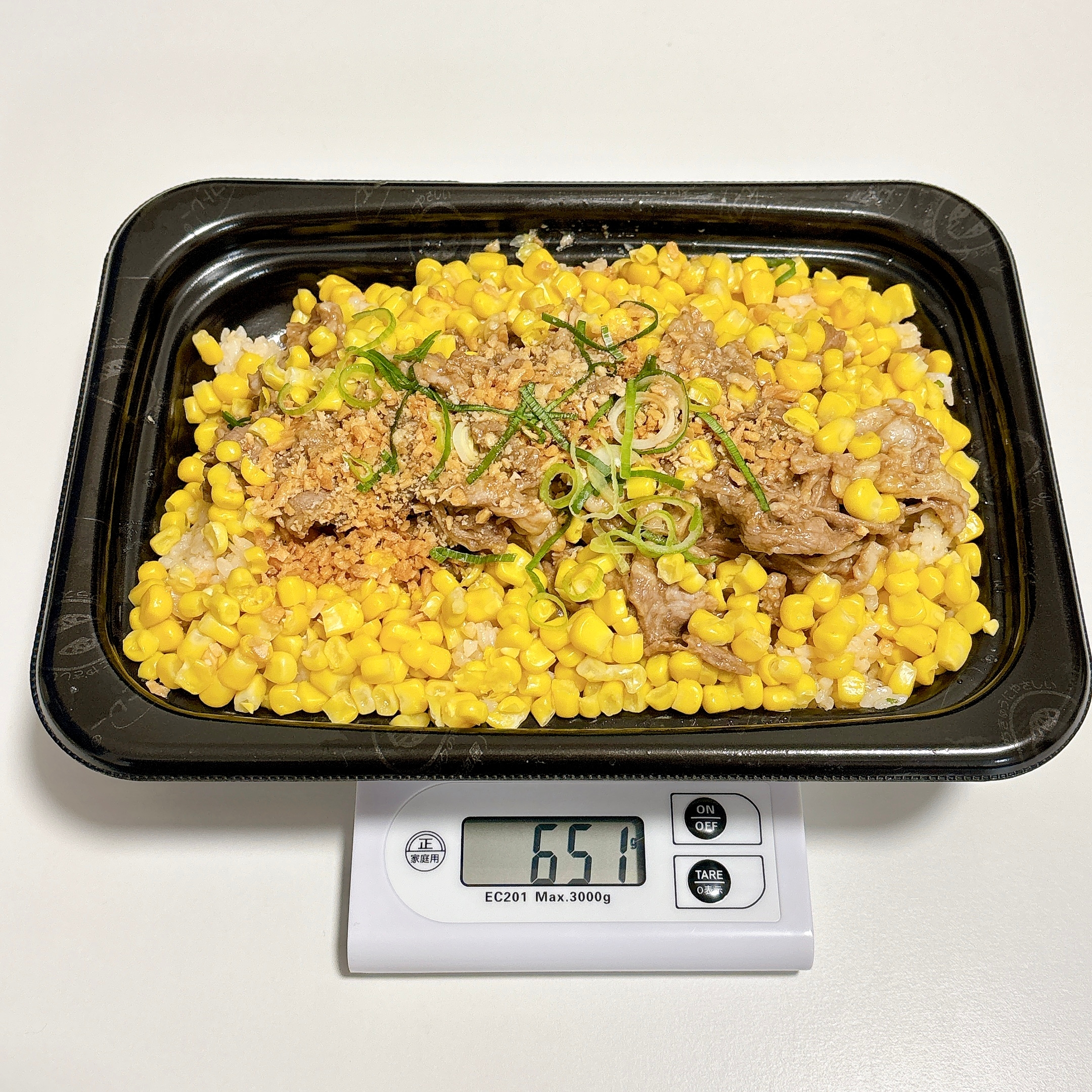 電子スケール上のトレイに盛られた、コーンと牛肉の料理が651グラムと表示されています。