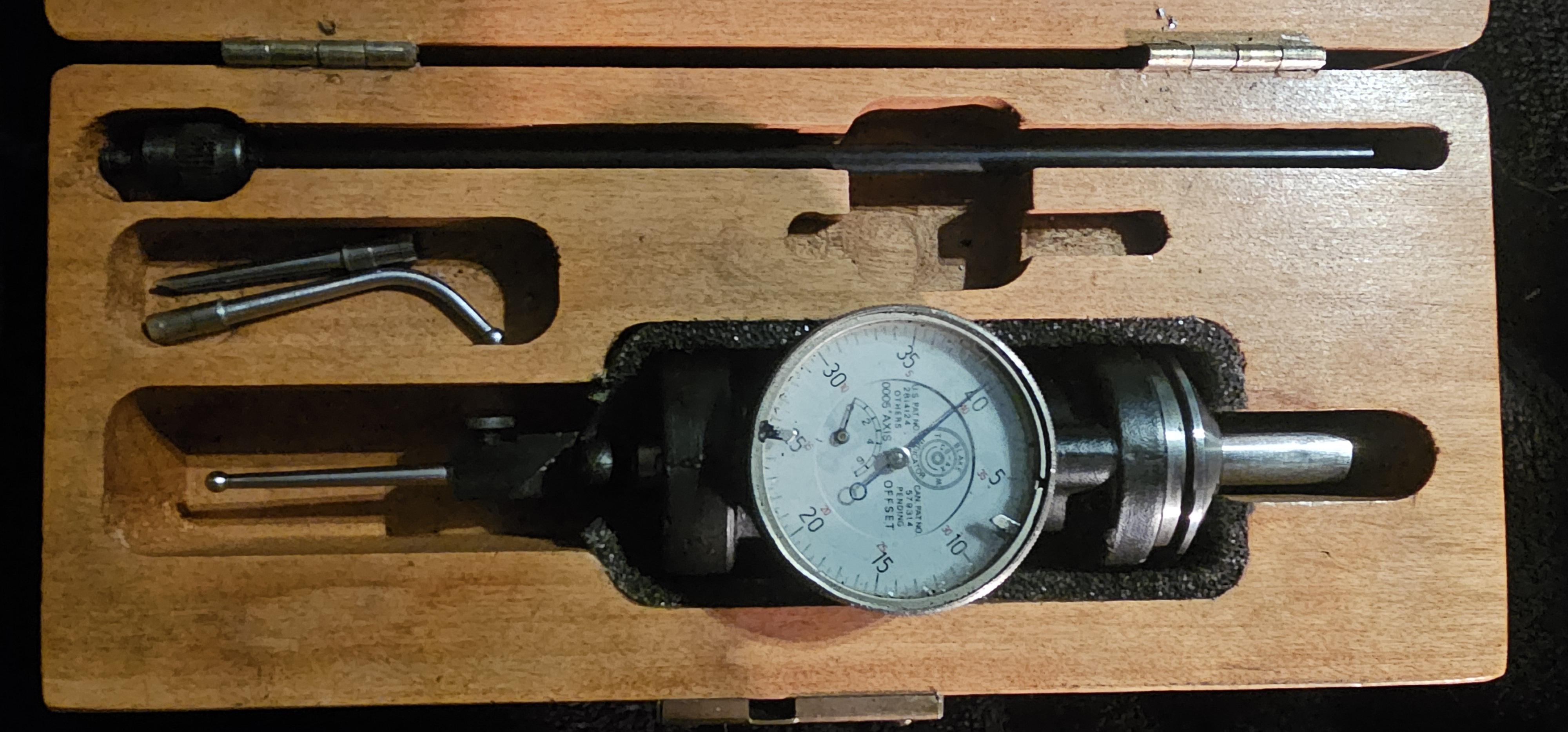 Dial indicator gauge set in a wooden case, including various accessories for precision measurements