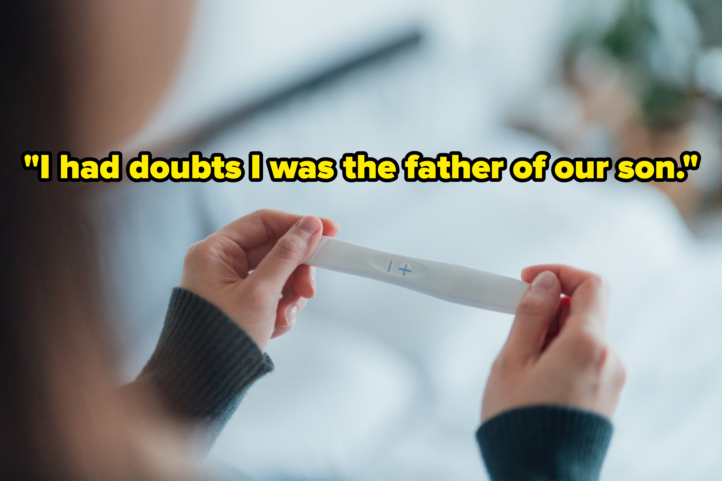 Person holding a positive pregnancy test, showing a plus sign, in a cozy indoor setting
