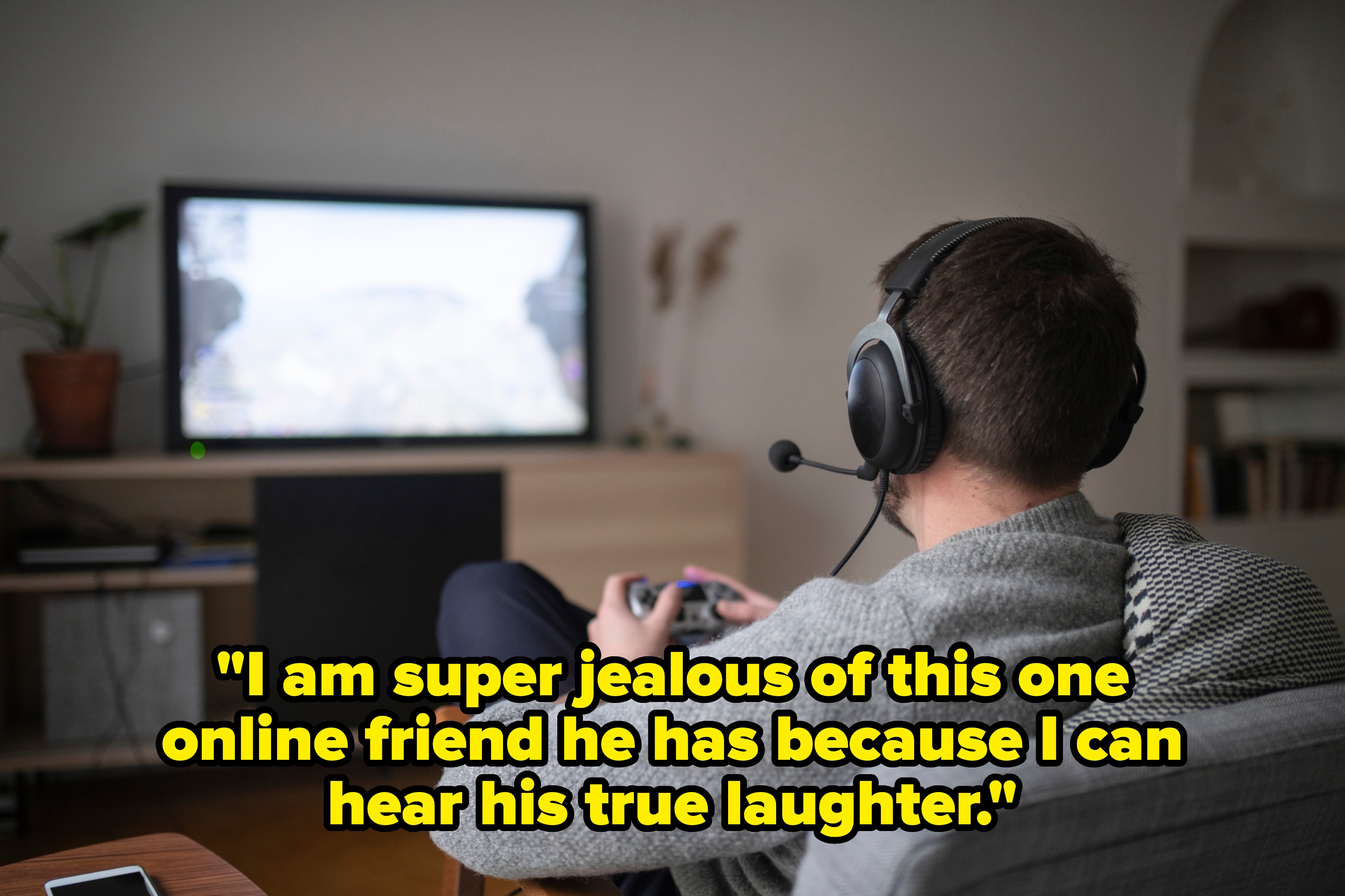 Person wearing headphones playing a video game on a TV in a living room