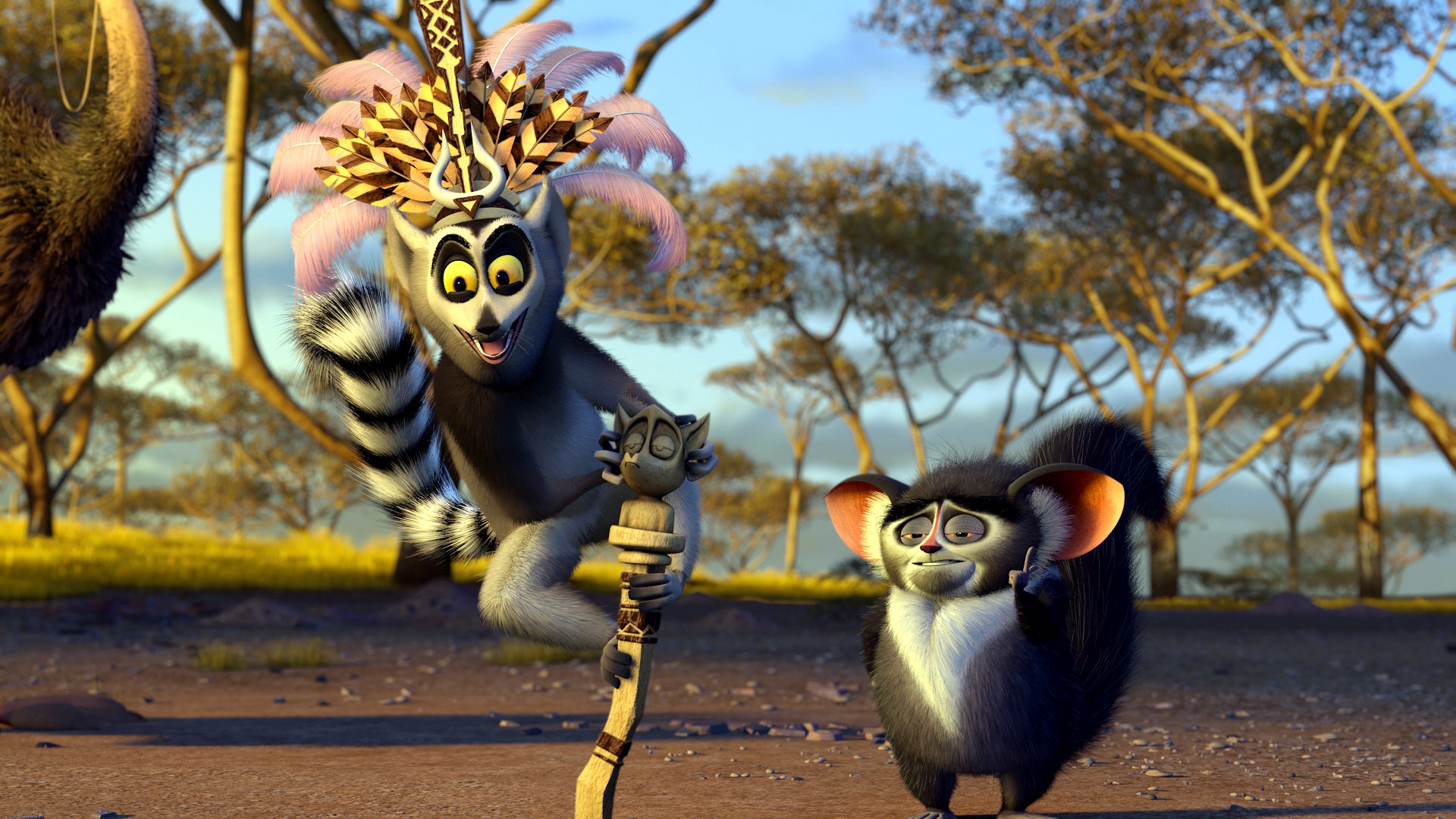 Animated lemurs, one with a crown and staff, in a savanna setting, possibly from a scene in an animated film