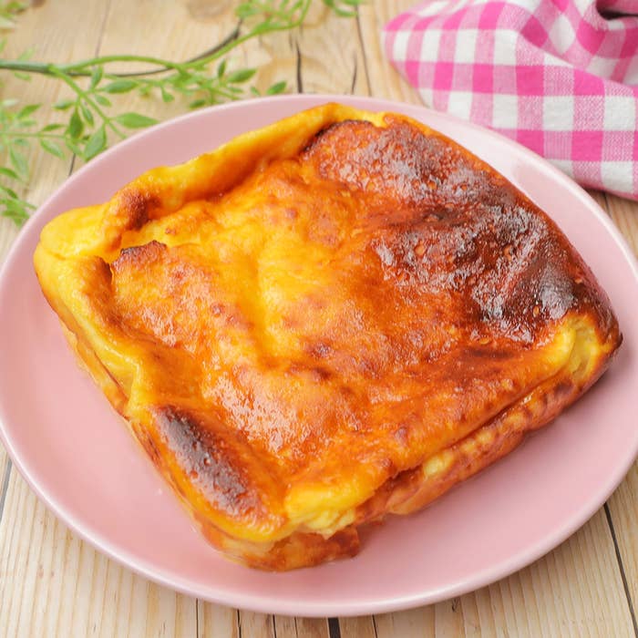 四角い焼きたてチーズケーキが木製テーブルに置かれている。