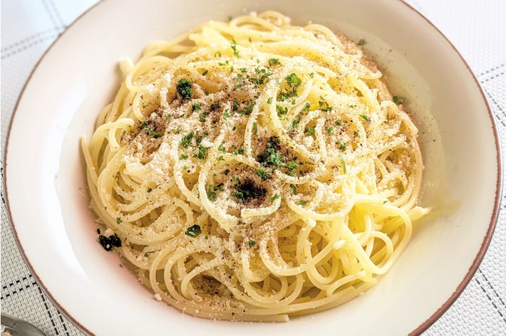 お皿に盛られたクリームチーズのスパゲッティ、パセリと粉チーズがトッピングされています。