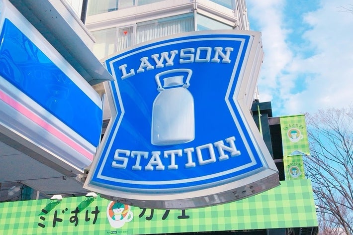 ローソンの看板が建物の前に設置されている。バックグラウンドに高層ビルが見える。