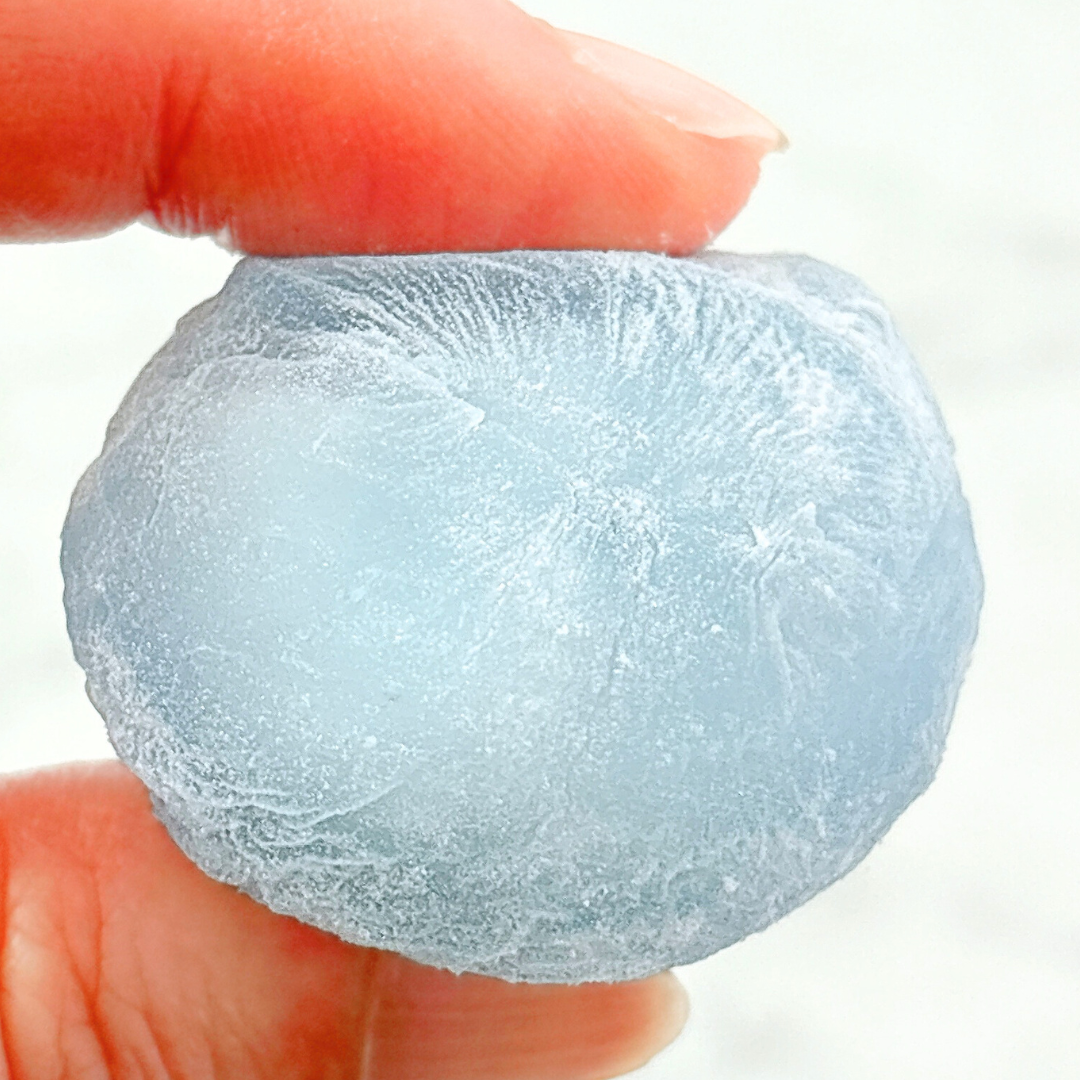 指でつまんだ氷の彫刻。繊細な模様が刻まれている。