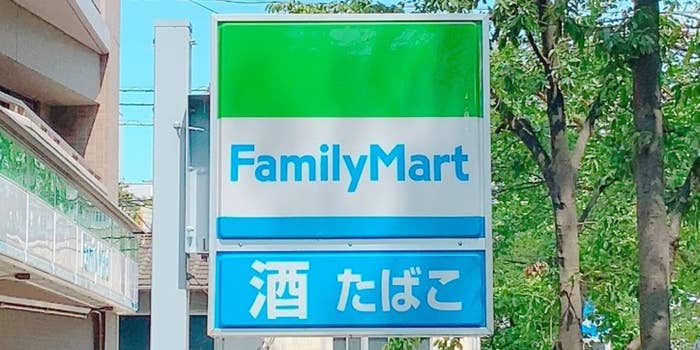 ファミリーマートの看板。日本語で「酒 たばこ」と書かれています。