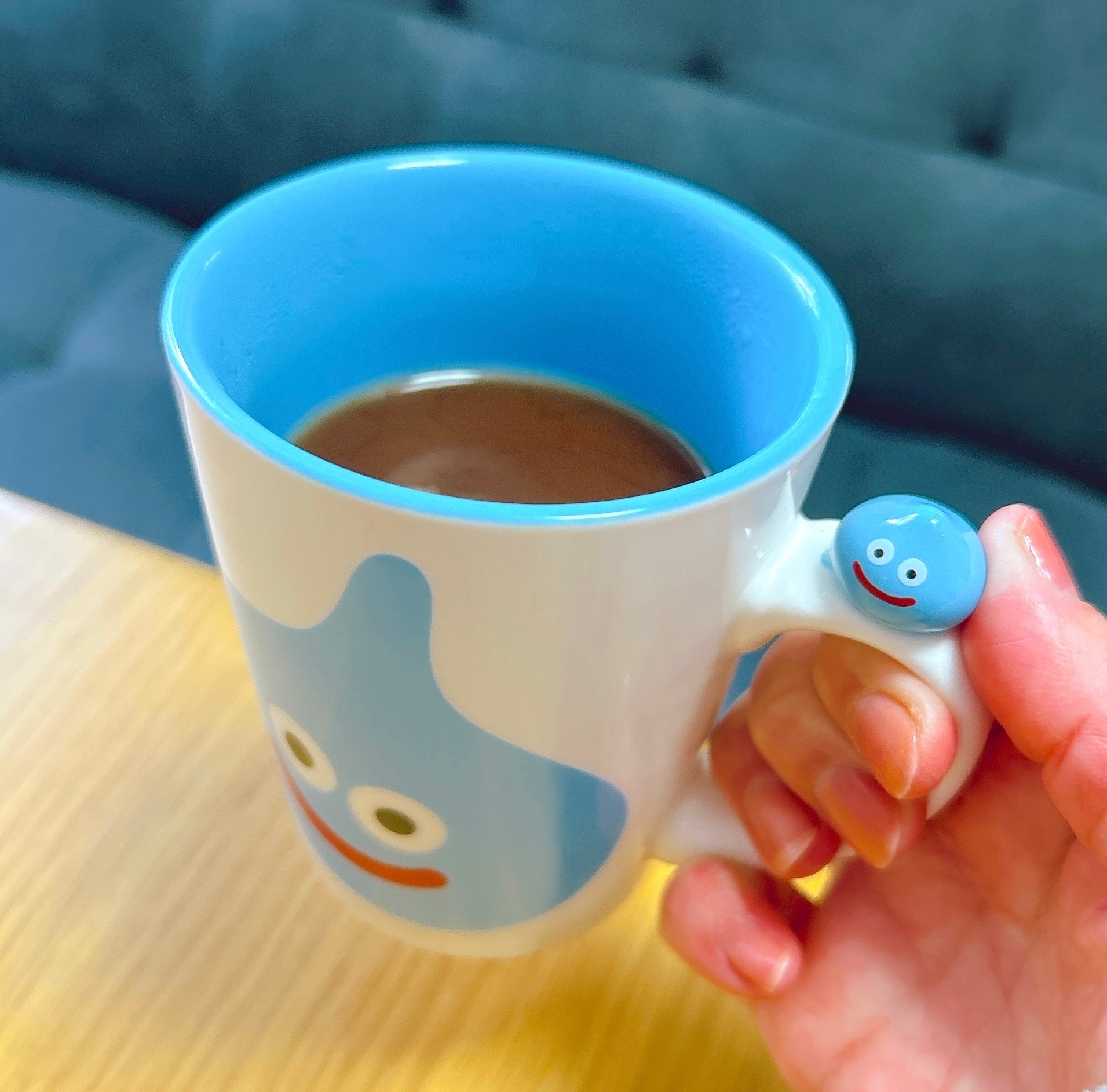 カップにコーヒー。取っ手にスライムのキャラクター装飾。