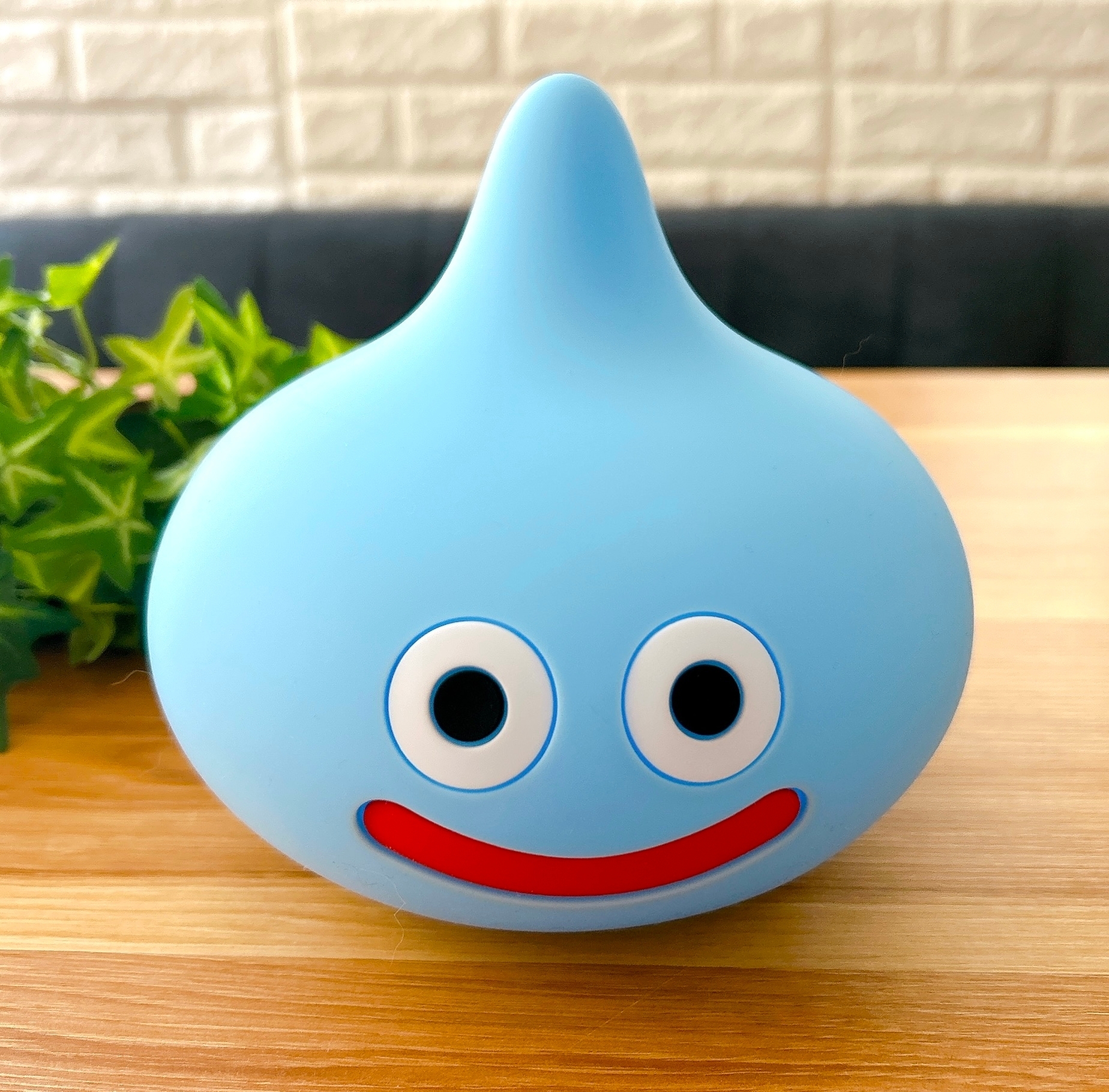 キャラクターの形をしたランプが机の上に置かれている。背景に植物が少し見える。