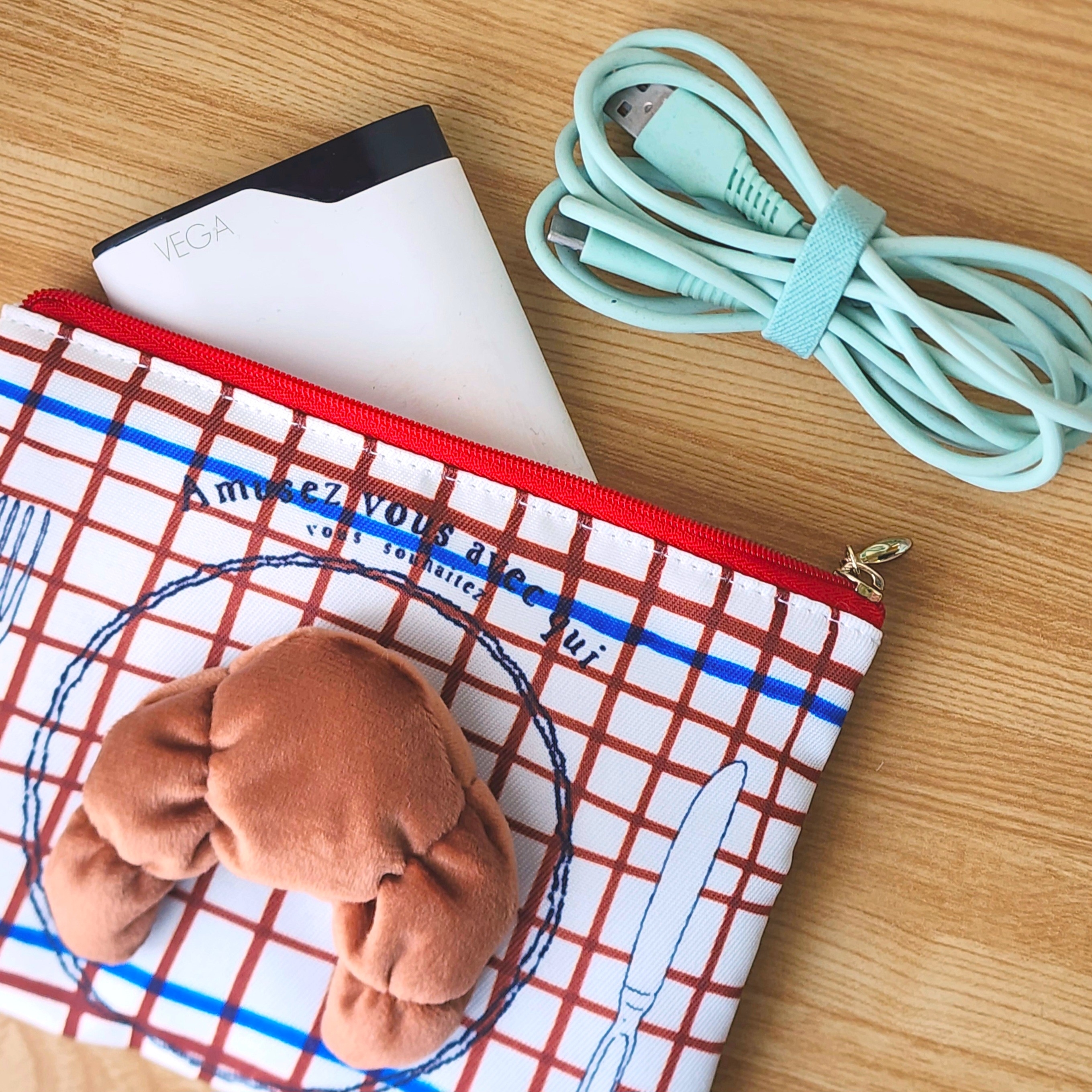 クロワッサンがついたポーチに充電器とケーブルが入っている。