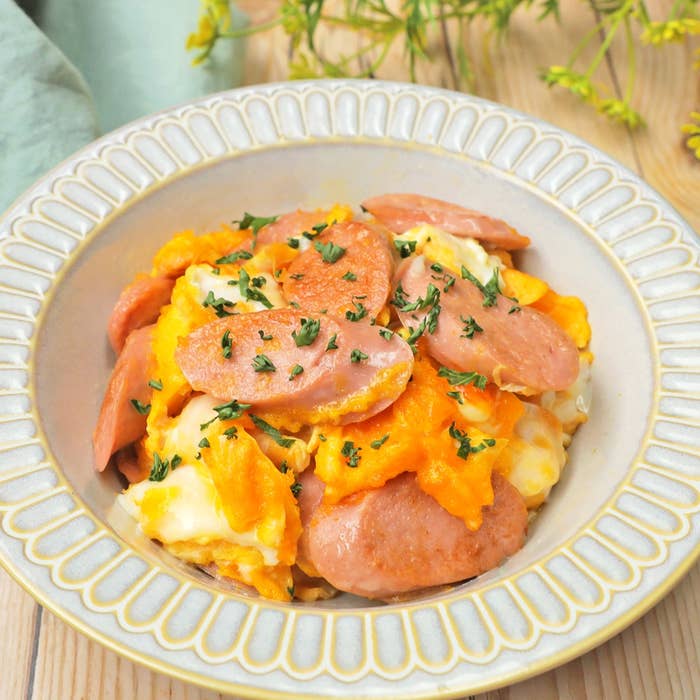 ソーセージとスクランブルエッグの盛り付けられた皿。パセリがトッピングされている。