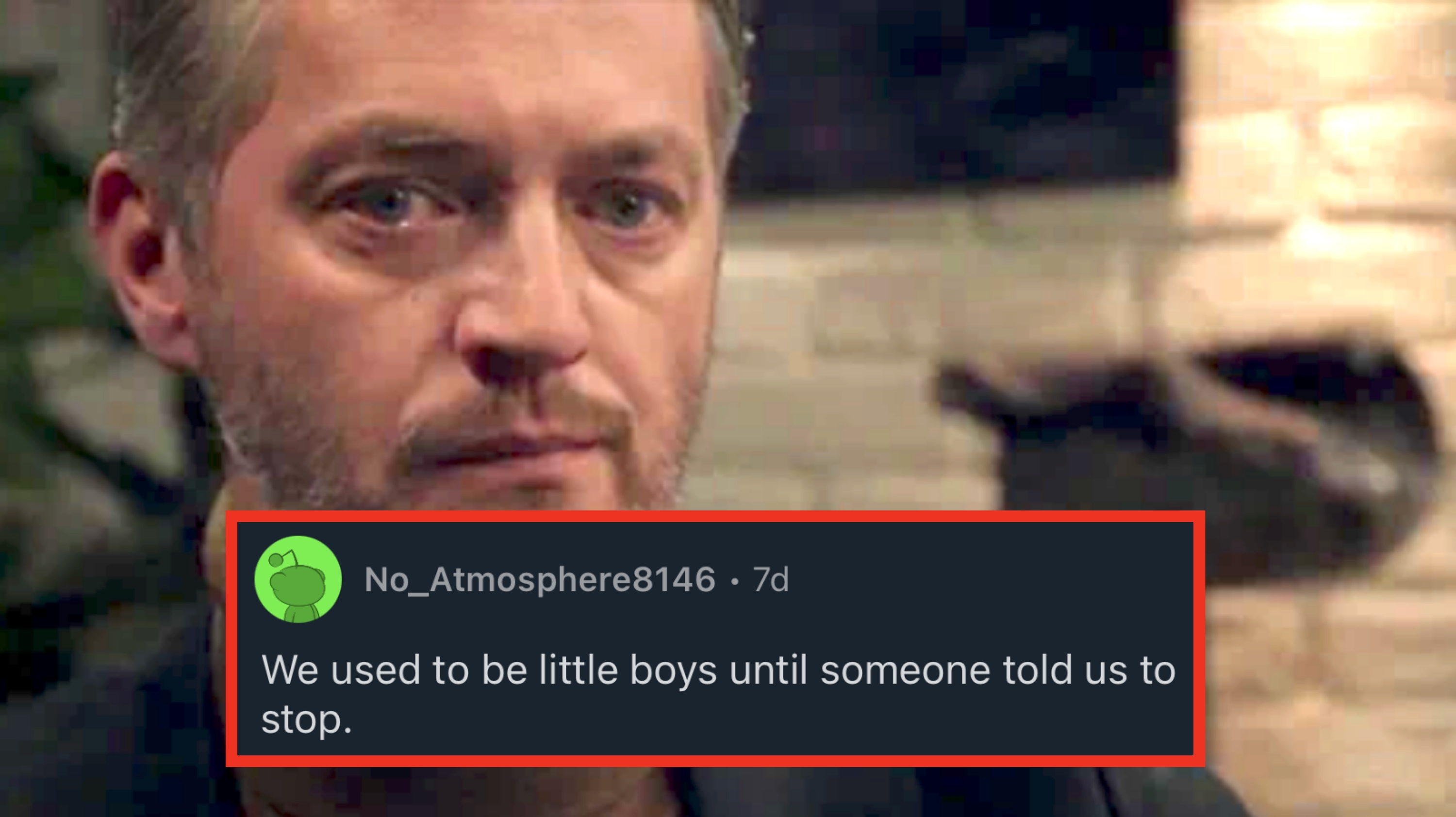 A person is sitting in a dimly lit setting with a thoughtful expression, wearing a dark jacket and a turtleneck