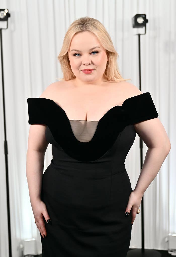 Person in an off-shoulder gown at a Neutrogena event, standing in front of a backdrop with lights