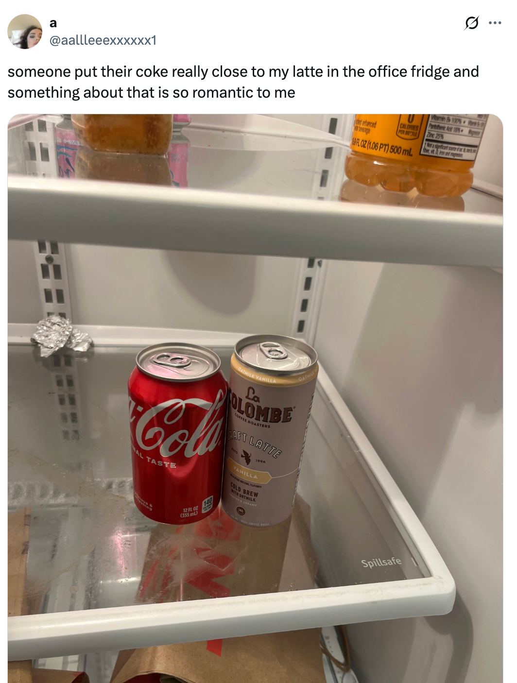 Cans of Coca-Cola and a coffee latte sit closely together in a fridge. Post text reads: "someone put their coke really close to my latte in the office fridge and something about that is so romantic to me."