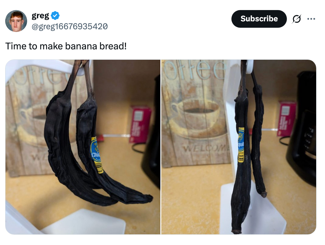Two overripe bananas on a kitchen counter, hanging from a banana stand. A text overlay reads "Time to make banana bread!"