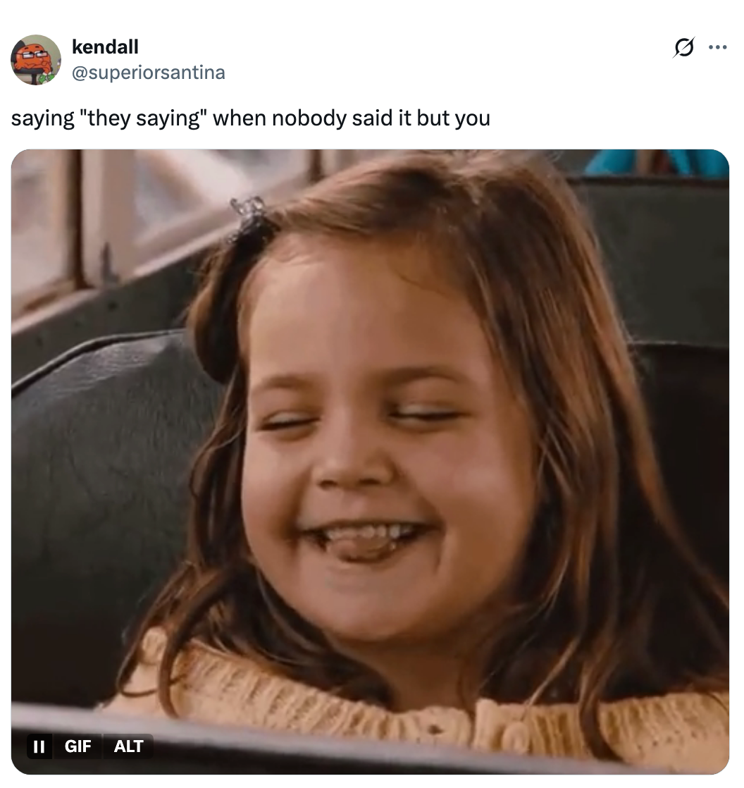 A young girl on a bus smiles mischievously. Text above reads: "saying 'they saying' when nobody said it but you."