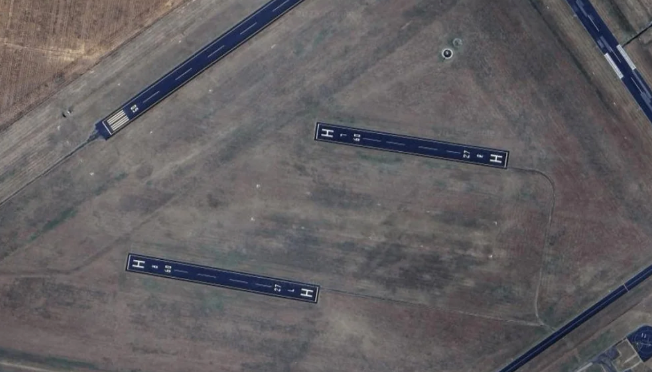 Aerial view of a triangular airport runway layout with two visible runways intersecting on a grassy field