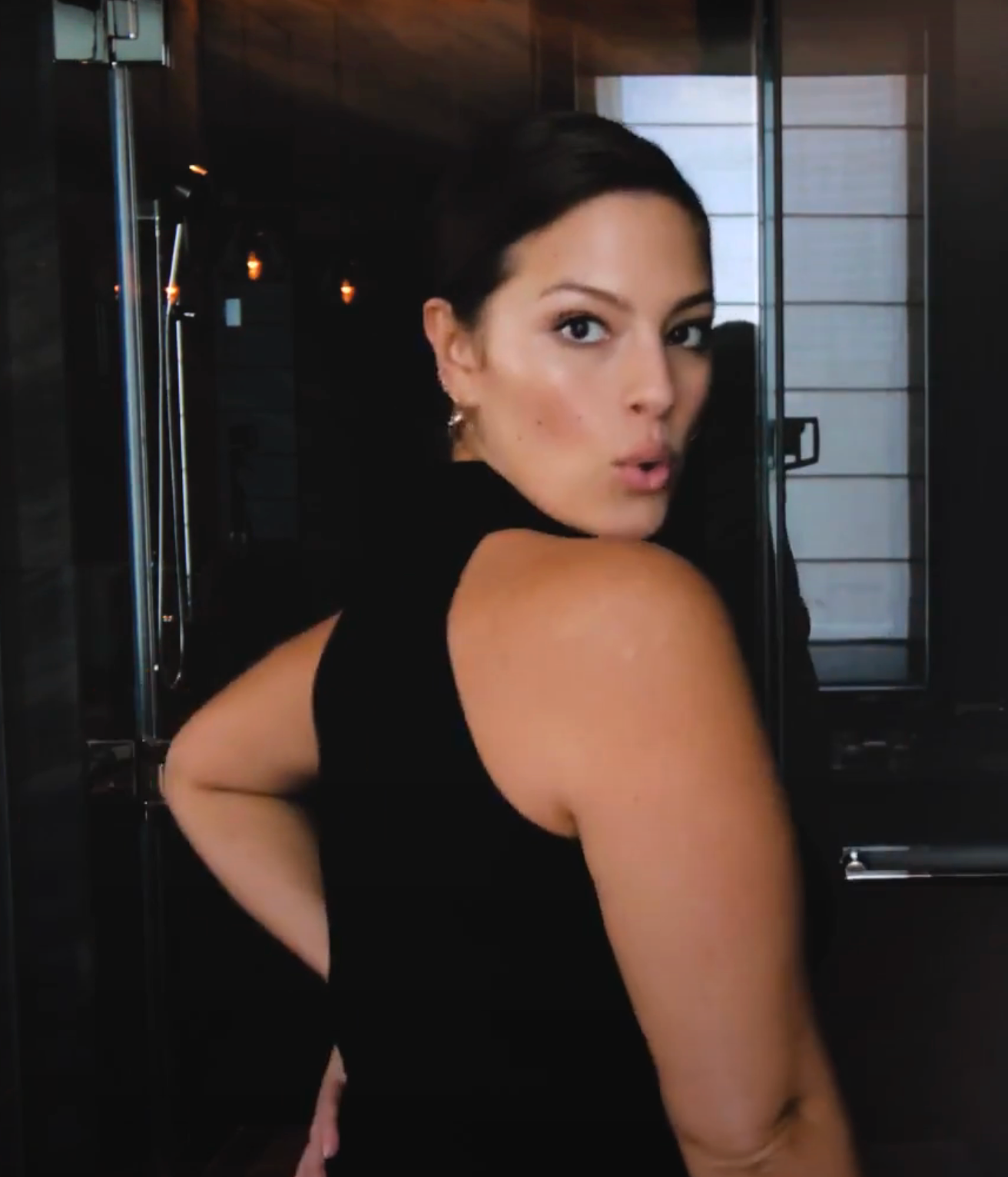 Ashley posing playfully with a simple, dewy makeup look