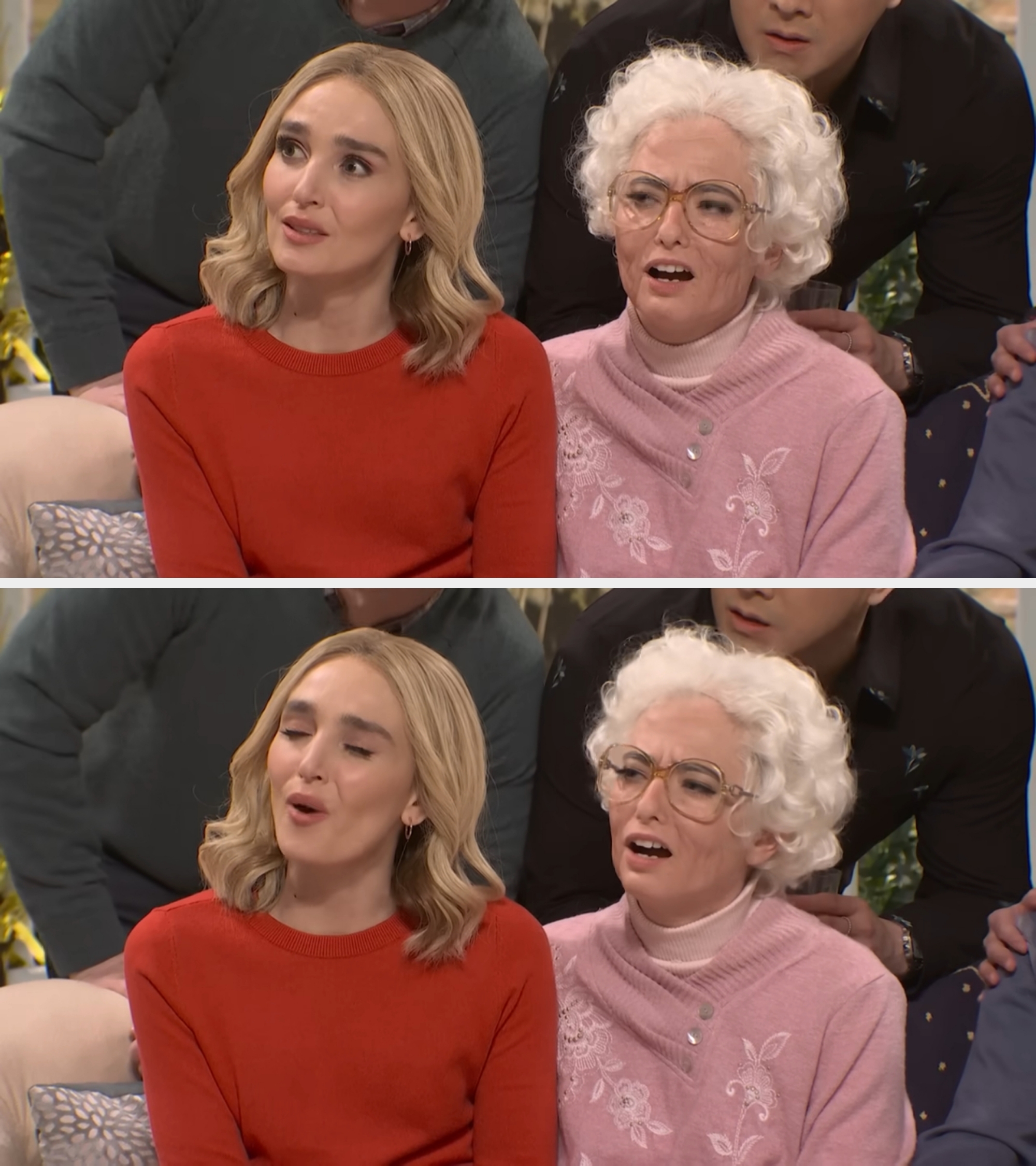 Two people sitting on a couch, one with styled hair in a sweater and the other in a wig and glasses, expressing a mix of emotions