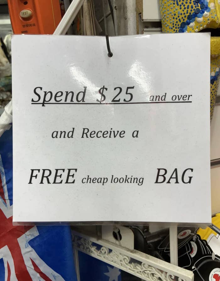 Sign offers a free "cheap looking" bag with a purchase of $25 or more