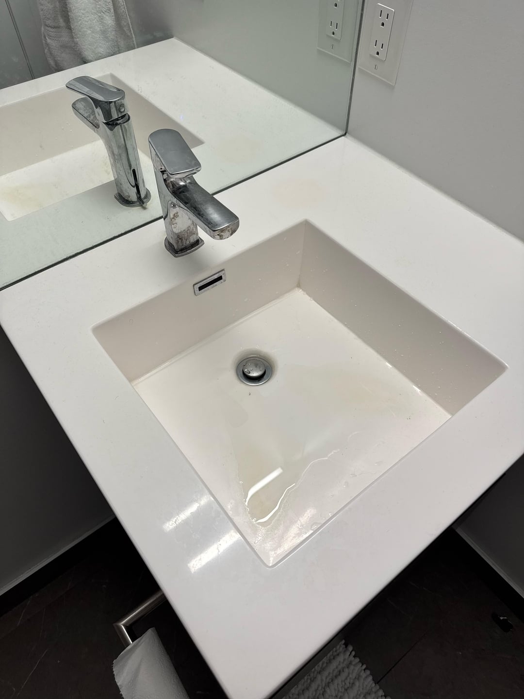 Modern bathroom with a square-shaped sink with a flat bottom. Water sits at the bottom without draining