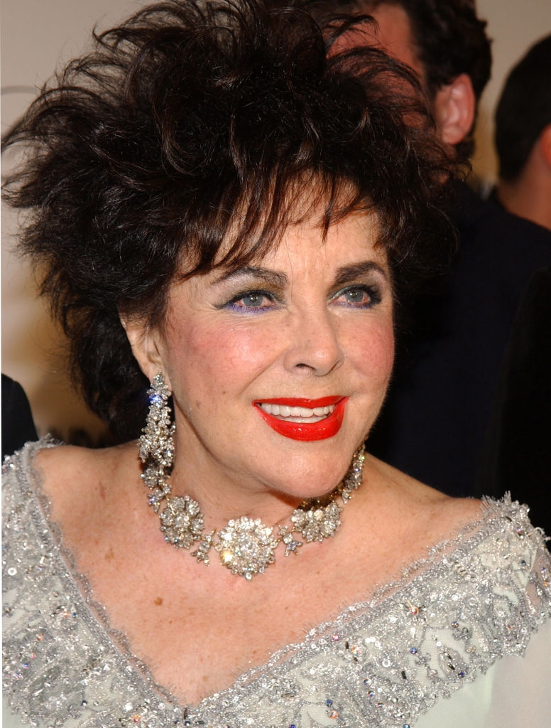 Elizabeth with bold lipstick, dark eyeliner, and a colorful eyeliner under her eyes