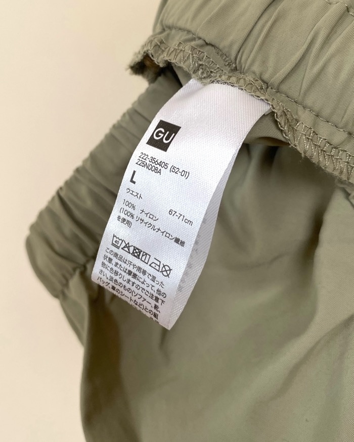 Clothing label showing size L, nylon composition, and washing instructions in English and Japanese, attached to a garment