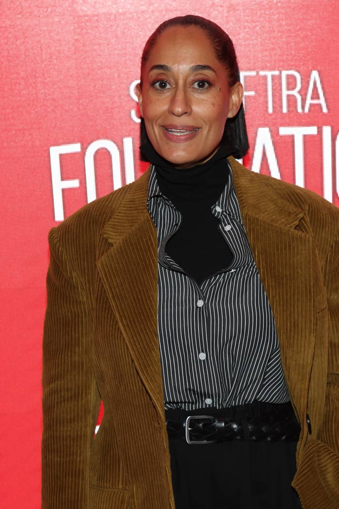 Tracee Ellis Ross in a corduroy blazer over striped shirt and turtleneck on a red carpet