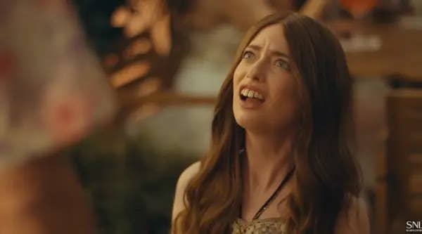 Woman with long hair looking up with a surprised expression, seated outdoors