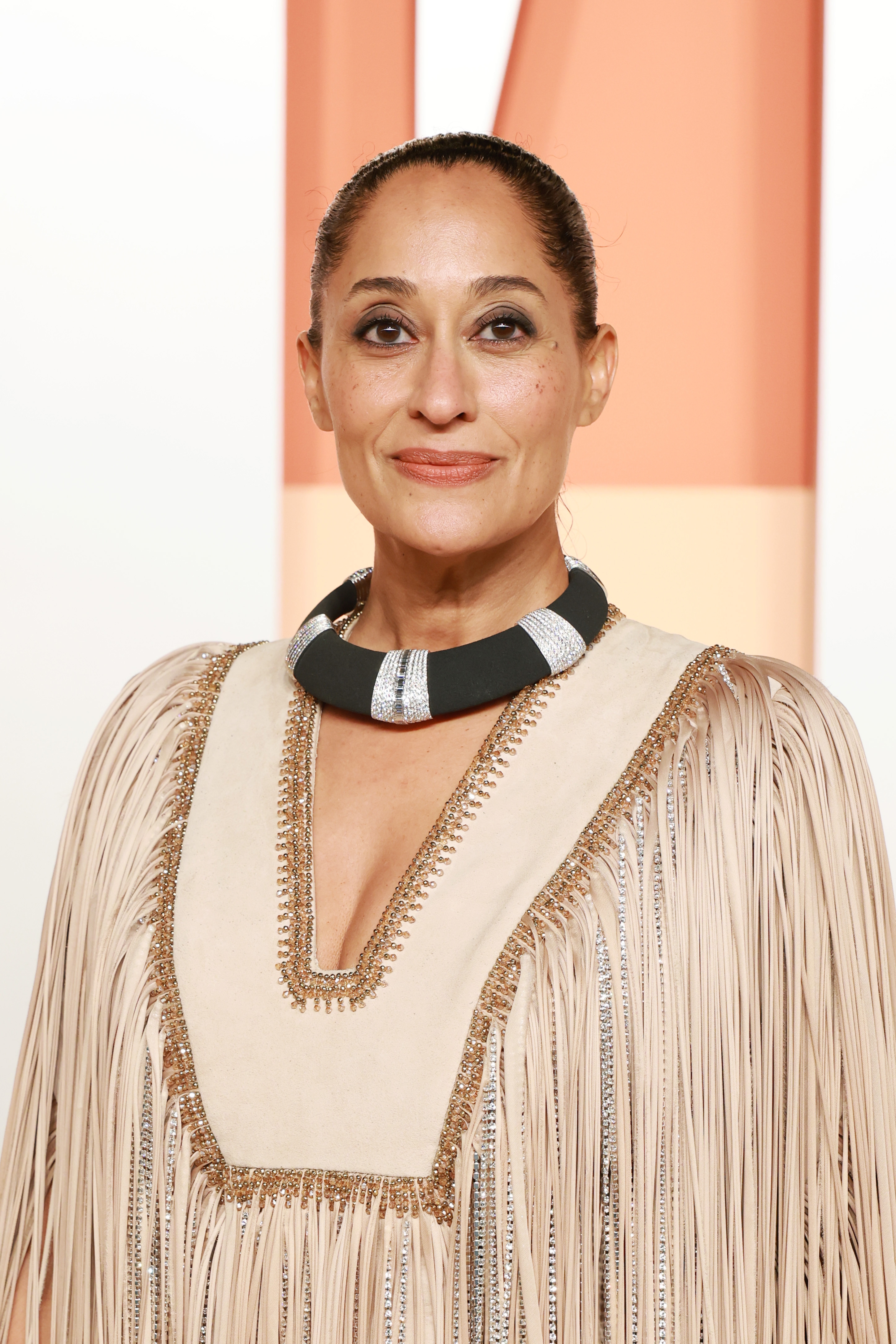 Tracee Ellis Ross in a fringed dress with a deep V-neck and a bold necklace at a formal event