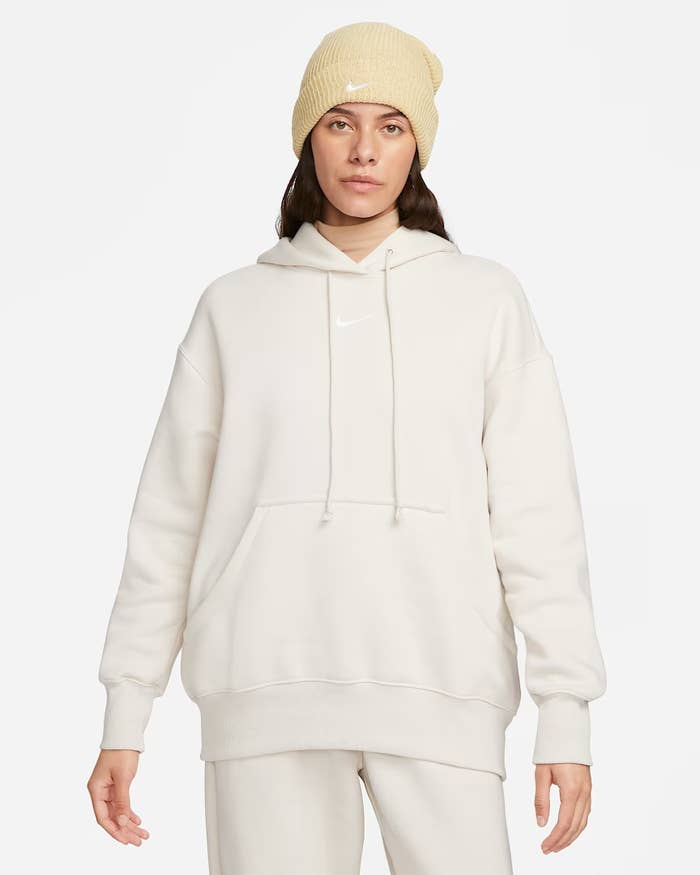 Orang yang mengenakan hoodie dan beanie yang nyaman, ideal untuk kenyamanan belanja santai
