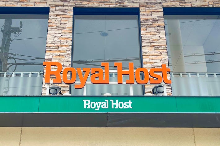 「Royal Host」レストランの外観。建物の石造りの壁と窓の下に看板が見える。