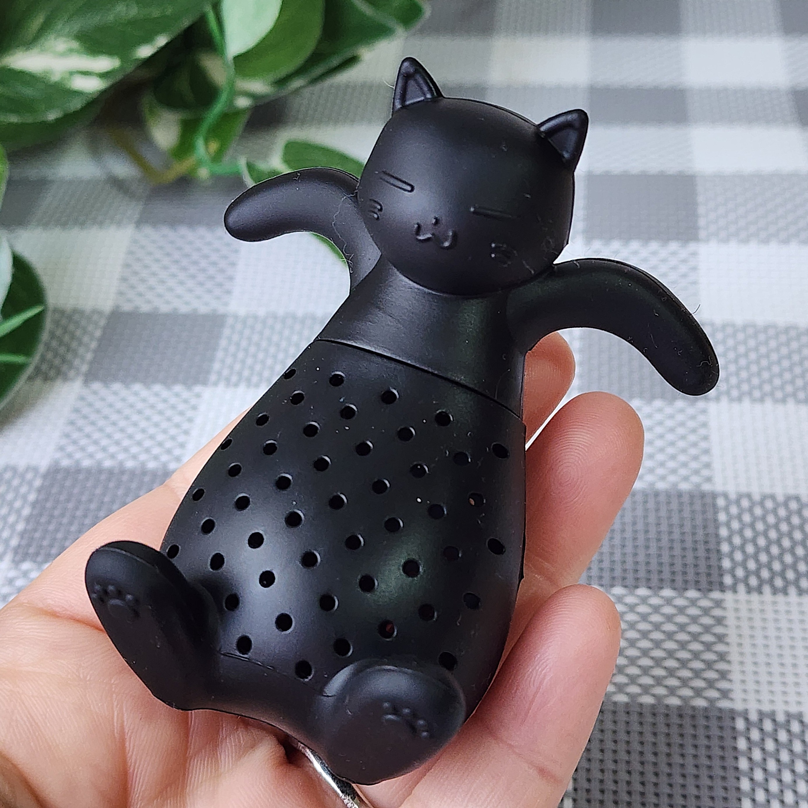 黒猫型のティーインフューザーが手のひらに乗せられている。かわいらしいデザイン。