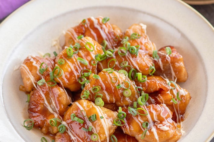 お皿に盛られた照り焼きチキン、上に刻みネギとソースがかかった料理。