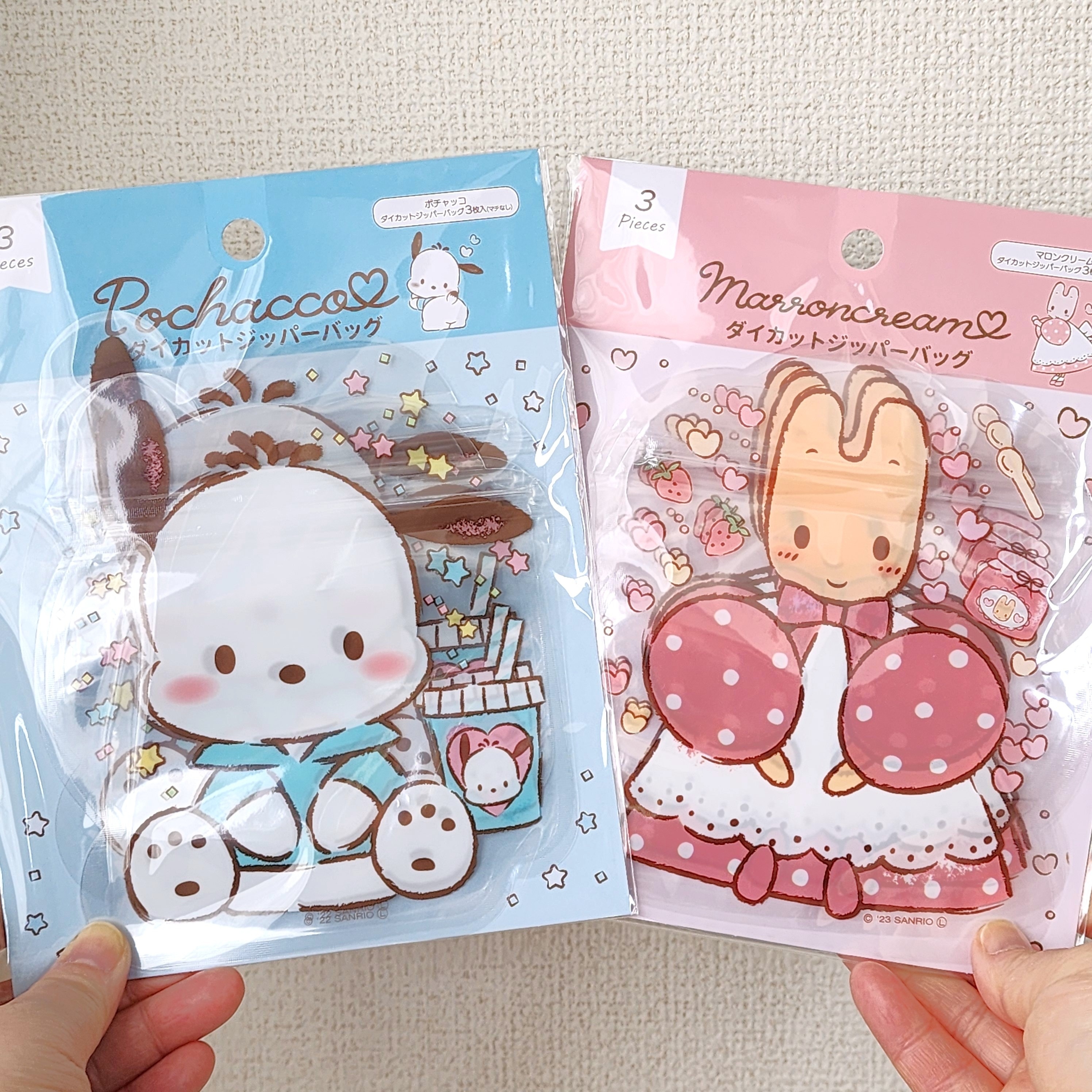 左手にポチャッコ、右手にマロンクリームのデザイン袋を持つ手。かわいいキャラクターが描かれています。