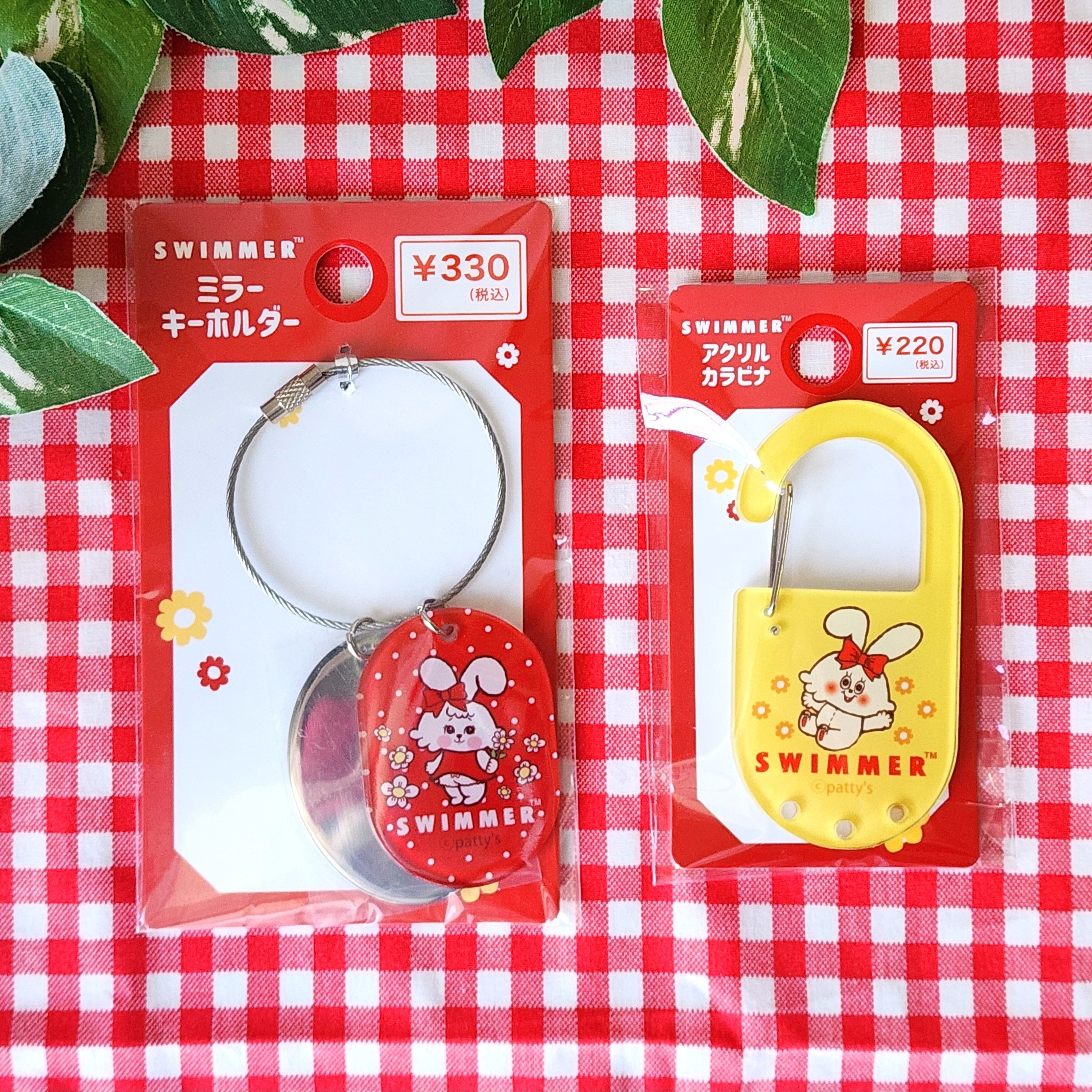 2つの「SWIMMER」ブランドの小物。左はミラーキーホルダー330円、右はアクセサリカバン220円。かわいいキャラクターデザイン。