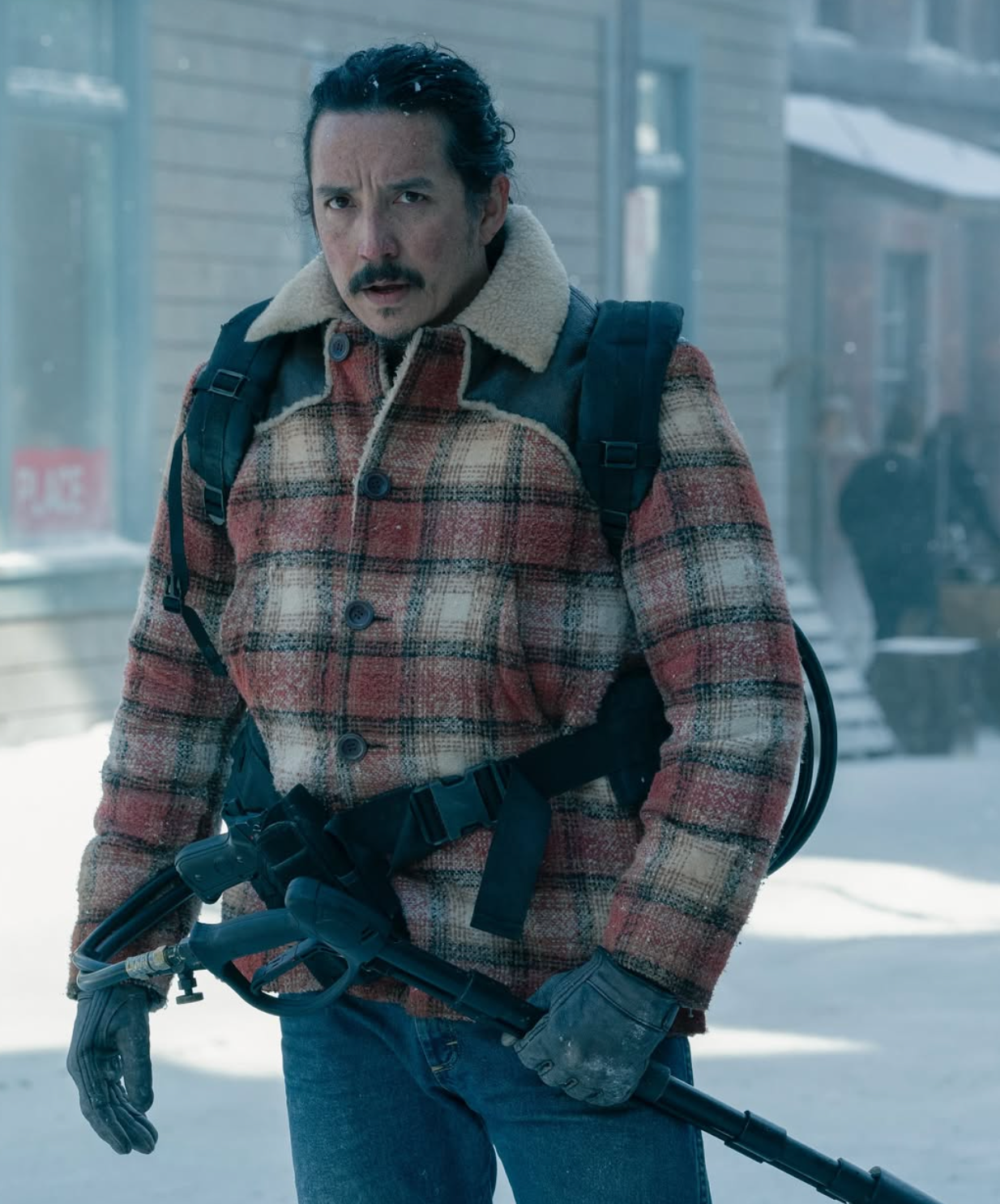 Persona en abrigo de cuadros con mochila, guantes y detector de metales. Escena invernal y urbana