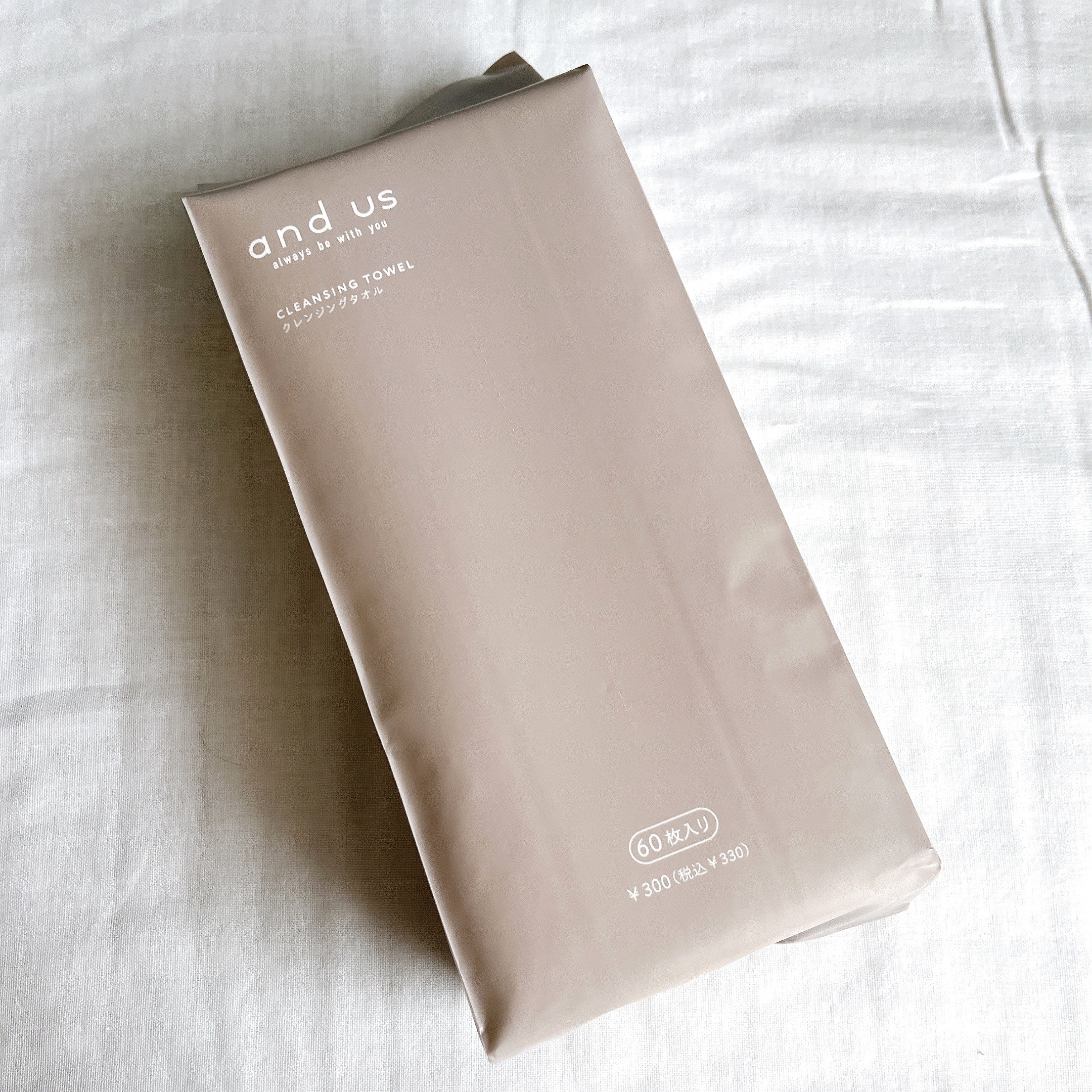 ベージュのパッケージに「and us」ブランドのクレンジングタオル(60枚入り)が表記されている。価格は300円。